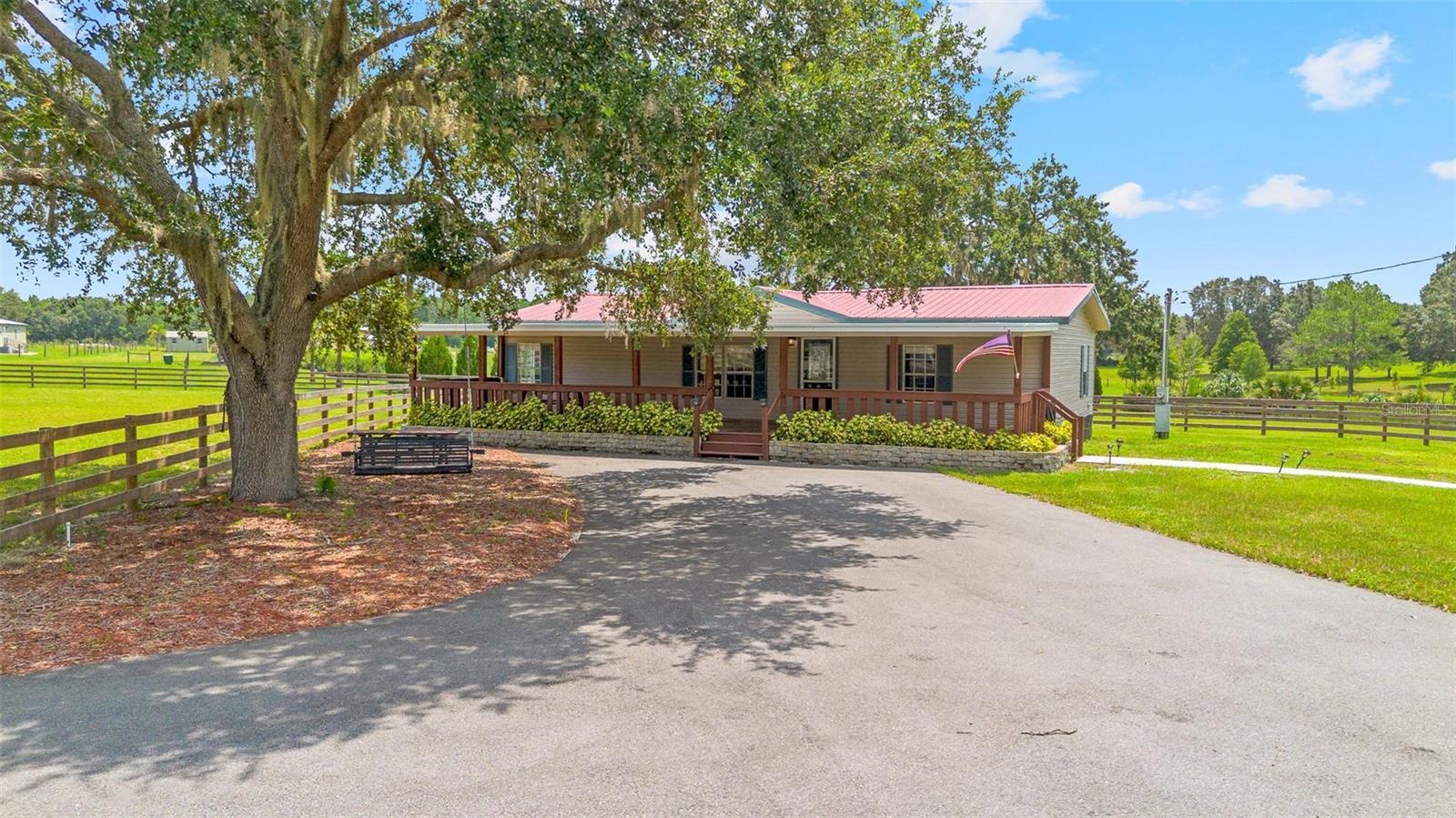 Welcome to your private equestrian retreat in highly desirable Umatilla. This beautifully remodeled three-bedroom, two-bath home sits on nearly five fenced acres and boasts top-of-the-line upgrades throughout. Inside, you’ll find luxury vinyl plank flooring, granite countertops, all-natural pine doors, brand-new appliances, Moen fixtures, and walk-in closets in every bedroom. The open split floorplan offers a bright and functional layout, complete with a cozy front porch and a large screened-in back porch that is ready to become your Florida room for added living space.
Equestrians and families will love the versatility of this property with plenty of room for growing families, guests, and horses. The twelve-stall barn was originally built for mini ponies, but with simple and cost-effective modifications to the windows and stalls it can be converted into an eight-stall barn for full-sized horses. It features aluminum doors, water in every stall, electricity, fans, an integrated fly spray system, a concrete center aisle wide enough for vehicles, a wash station, and a resurfaced roof. The land is cross-fenced into four separate pastures, each with water access, and two of the pastures include additional structures for livestock shelter. A newly paved patterned driveway leads from the electric gate with keypad all the way to the home and barn, offering both security and style.
This property is also ideally located. It is less than a mile to the Lake Yale boat ramp, which is a favorite destination for fishing, hunting, boating, and more. Just down the road you will also find Sawgrass Island Preserve, which spans over 1,100 acres and offers nearly eight miles of scenic trails that are perfect for horseback riding or hiking. Despite its quiet and private feel, the home is only fifteen minutes from Publix and town, allowing you to enjoy peaceful country living without being isolated. Whether you are dreaming of a horse farm, a hobby homestead, or simply a little extra elbow room, this one-of-a-kind property delivers luxury, functionality, and endless potential.