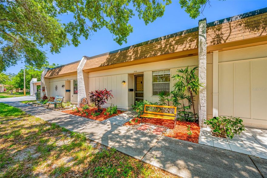 One or more photo(s) has been virtually staged. Step into comfort and convenience with this charming 1-bedroom, 1-bath villa-style condo in the friendly 55+ community of Mission Hills, where no flood insurance is required and a relaxed Florida lifestyle awaits. Bright and well-maintained, this land lease condo features quality vinyl flooring and a spacious Florida Room with serene views of the beautifully landscaped green space. Residents enjoy an active and social atmosphere with regular Bingo, card games, group dinners, and access to amenities including a heated pool, shuffleboard, ping pong, a clubhouse, and a library. The villa offers a covered carport, guest parking, a large storage closet, and a cozy front patio for morning coffee or evening chats with neighbors. Located in a prime Clearwater area just minutes from Publix, Bayside Plaza, local favorites like Johnny’s Italian, and an easy drive to world-famous beaches, shopping centers, airports, and top medical facilities, this home makes daily living feel effortless. The community laundry room is conveniently close, and the monthly condo fee includes lawn care, roof maintenance, basic cable, Wi-Fi, gas, and other key utilities, making it a worry-free option for year-round or seasonal living.