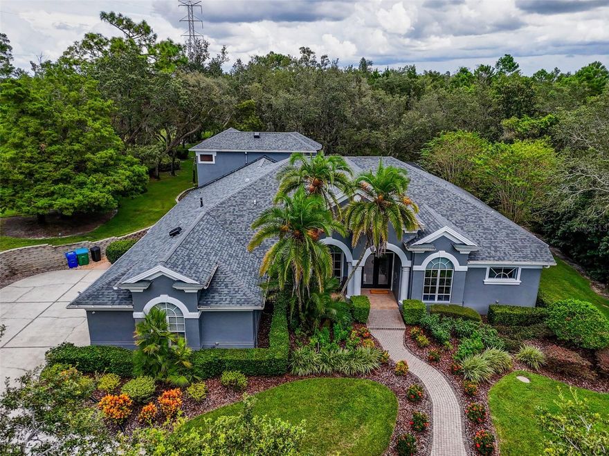 DO NOT MISS OUT ON THIS ONE BEFORE THE HOLIDAYS...HUGE PRICE IMPROVEMENT!!!!! Welcome to this stunning Marc Rutenberg residential designed home offering the perfect blend of space, comfort, elegance & privacy. Featuring 5 spacious bedrooms, and 3 full bathrooms, a dedicated office, and a game room space for fun and Sunday sports. The primary suite is a true retreat, featuring an expansive bathroom with a luxurious soaking tub, oversized walk-in shower, and dual vanities. Through the bathroom, you'll find an extremely spacious master closet offering an abundance of storage, as well as an additional separate walk-in closet-perfectly designed for ones spouse. On the opposite side of the home, the thoughtful split bedroom layout provides two bedrooms and a bathroom, while another two bedrooms share a full bathroom nearby. From this wing, a staircase leads to the upstairs game room. This home is designed to accommodate both family living and entertaining with ease. The heart of the home offers two inviting living rooms and a kitchen that opens to serene views of the sparkling solar heated salt water pool and spa, creating a seamless indoor-outdoor lifestyle. The pool solar panels are fully paid off. This home is nestled on 2 or more acres of beautifully manicured, mature landscaping at the almost end of a quiet dead-end road Cul-De-Sac, the setting provides unmatched privacy, charm, and feel of resort style living. Did I mention NO HOA? Every detail, from the expansive grounds to the resort-inspired outdoor space, makes this home a true sanctuary while you practice your putting on the green out back. This home has been thoughtfully updated with valuable features, including a whole-home Generac generator(2019), New shingle roof(2021), and a tankless water heater(2019). Additionally enhancements include a water softener(2025), hurricane-anchored pool cage(2021), and replacement of one of the two 5-ton HVAC units(2025). Enjoy a whole-home integrated speaker system with seamless indoor and outdoor audio-perfect for entertaining. With many more upgrades detailed in the attachments, this property has been meticulously maintained to provide comfort, efficiency, and peace of mind for years to come.