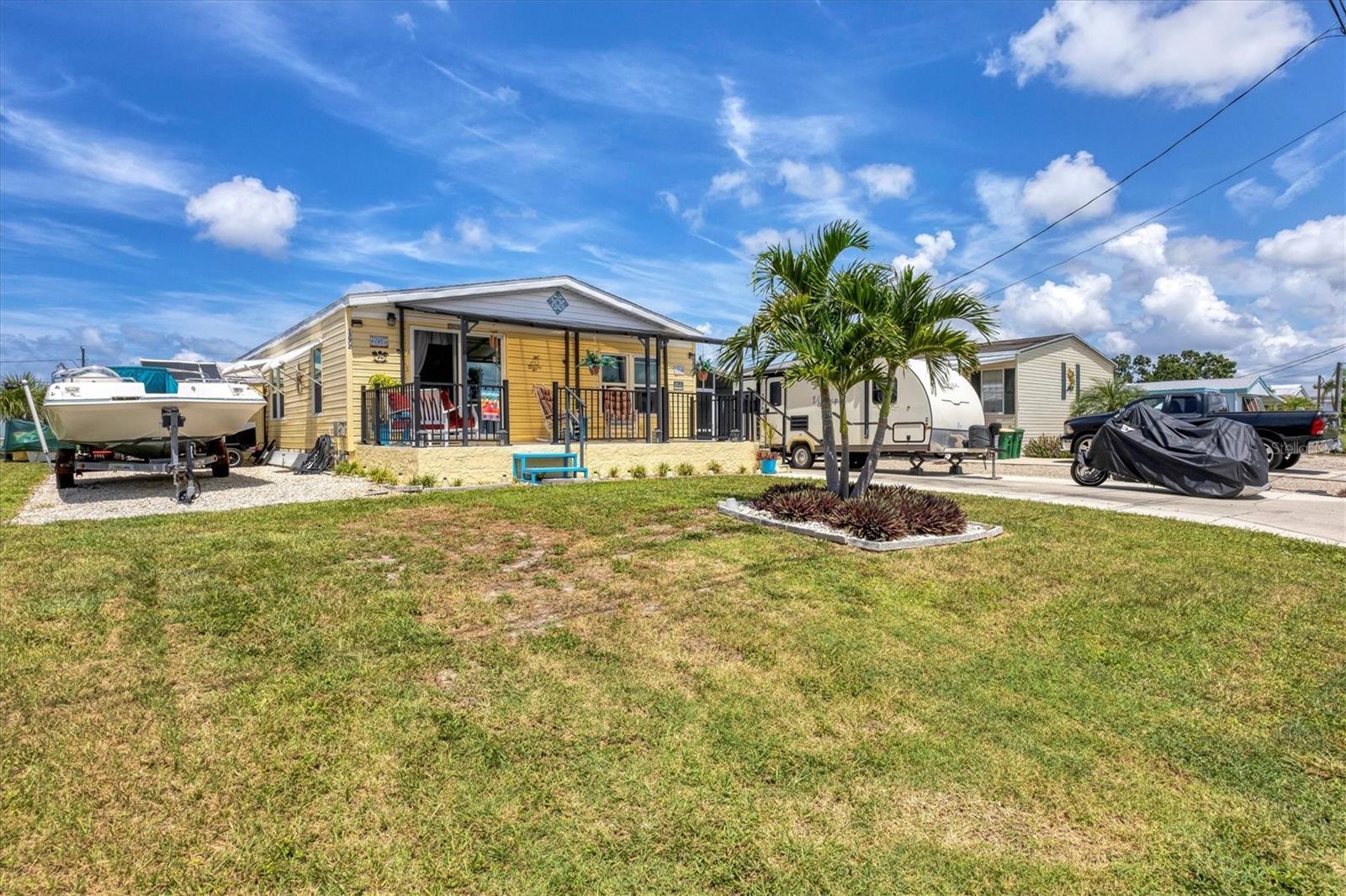 Waterfront living at its best! This spacious double-wide mobile home with high ceilings has been beautifully remodeled inside and offers direct GULF access with only one bridge to open water. Enjoy peace of mind with a 2022 roof and a 2013 dock with 2019 extension, perfect for your boat. The outdoor oasis is designed for Florida fun with an above-ground pool, hot tub, his-and-her sheds, and an additional shed with washer and dryer. Entertain with ease on the huge screened back porch, relax on the front porch, or host friends around the dry bar. A spacious main driveway plus an extra driveway on the other side of the home provides plenty of parking, including room for your boat or trailer. You own the land—no lot rent—making this move-in-ready waterfront retreat the perfect place to call home!
