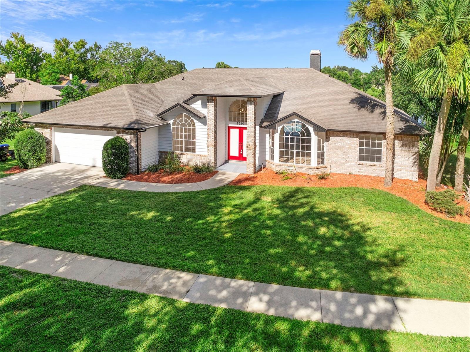 One or more photo(s) has been virtually staged. Experience waterfront elegance at its finest with this newly listed masterpiece on Almond Tree Court. Set on a half-acre lot with no front or rear neighbors, this stunning four-bedroom, three-bathroom estate offers breathtaking lake views, ultimate privacy, and turnkey luxury living. Updated from the ground up, the home features brand-new flooring, fully renovated kitchen and bathrooms, recessed lighting, and elegant modern fixtures, creating a perfect harmony of sophistication and comfort. Step through the grand foyer, where 14-foot ceilings, brick pillars, and double French doors with integrated blinds make a striking first impression. The open-concept floor plan effortlessly showcases the resurfaced pool and serene lake beyond, framing a perfect panorama that blends indoor elegance with outdoor tranquility—ideal for entertaining or peaceful retreat-style living. The formal living room, to the right of the entrance, features a charming wood-burning fireplace, while the adjacent dining area opens seamlessly to the heart of the home—the fully renovated kitchen. Culinary enthusiasts will delight in the quartz countertops, waterfall kitchen island, modern electric temperature-controlled faucet, and stacked convection oven with microwave. Expansive counter space and sophisticated finishes make this kitchen as functional as it is beautiful. The primary suite is a private sanctuary, offering sliding doors to the pool lanai and uninterrupted waterfront views. The spa-inspired bath features a standalone shower, jetted soaking tub, dual quartz vanities, and an expansive walk-in closet. Thoughtful design extends to pool access with a dedicated bathroom for easy entry, perfect for children or guests. Every detail has been considered for comfort and elegance: one of the guest bathrooms also features sliding doors with views of the pool and lake, the sprinkler system is fully programmable, and the chlorine pool boasts lights, a 6-foot depth, a waterfall, and recently updated plumbing, creating a serene retreat for relaxation or entertaining. Additional highlights include a 2017 roof, a 2021 AC system, washer and dryer, and proximity to top-rated schools, major freeways, and a wealth of family-friendly activities. With no compromise on privacy, space, or luxury, 1219 Almond Tree Court is more than a home—it’s a statement of sophistication, comfort, and lifestyle. Experience the perfect blend of elegance, modern upgrades, and breathtaking waterfront living in the heart of Orlando.