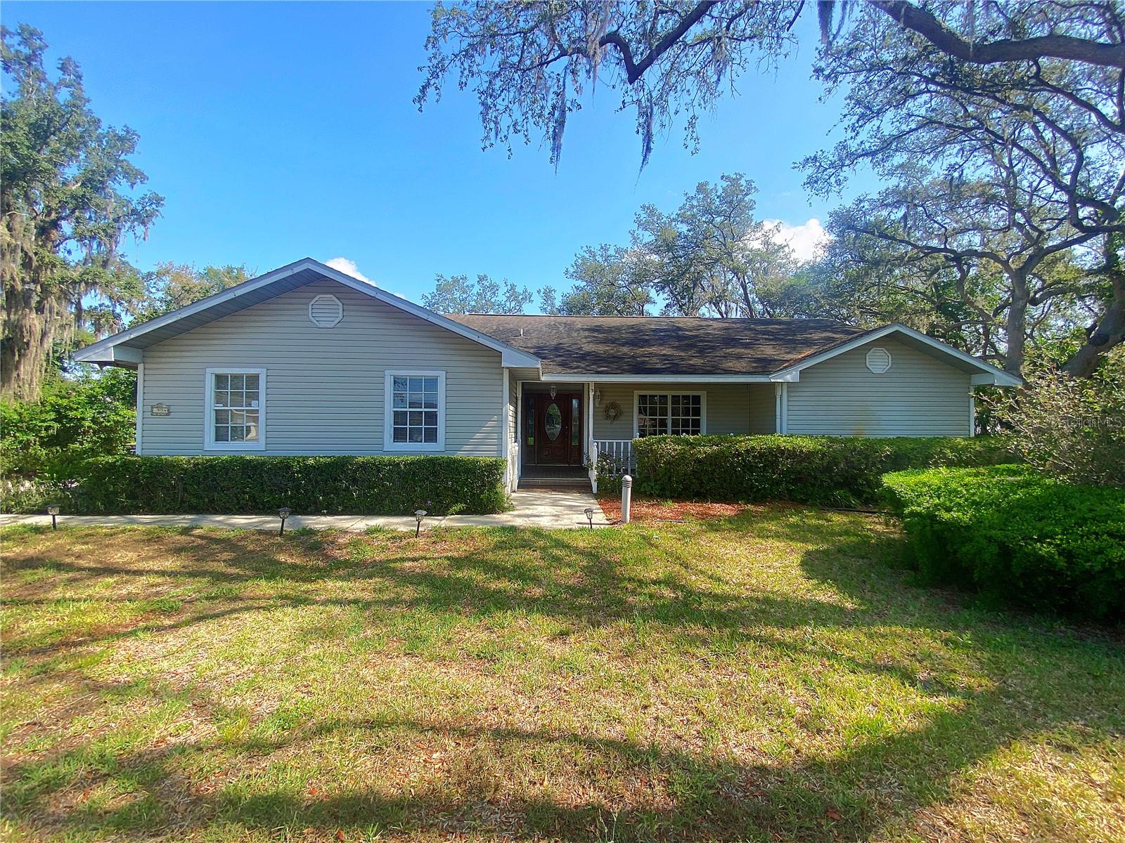 Welcome to your next home in the highly sought-after Country Oaks community of Lake Wales! This expansive 4-bedroom, 2-bath residence sits on an oversized corner lot and offers the perfect combination of comfort, functionality, and charm. Step onto the quaint front porch with elegant brick flooring, setting the tone for the inviting interiors. The foyer includes a convenient coat closet and opens to a spacious combined living and dining area, ideal for both everyday living and entertaining. French doors from the dining room lead to a huge, screened back lanai, creating a seamless indoor-outdoor flow. The kitchen is a chef’s dream, boasting updated cabinets, granite countertops, and ample storage space. A cooktop with a double wall oven enhances functionality, while the center island features a double stainless steel sink and an attached high-top table with seating for four. The open-concept layout continues into the family room, making it the perfect hub for gatherings. Three well-appointed guest bedrooms and a full guest bath are located just off the family room, offering privacy and comfort. On the opposite side of the home, the master suite provides a private retreat with French doors to the lanai, accent lighting, and a luxurious en-suite bathroom featuring dual sinks, vanity area, garden tub, separate shower, private toilet closet, and walk-in closet. Enjoy Florida living at its finest on the spacious screened lanai, perfect for entertaining or relaxing in peace. Strategically placed landscaping ensures privacy while enjoying the backyard pergola and serene surroundings. Additional features include a one-car garage with extra storage space and a pet-friendly policy. (Sorry, NO smoking allowed.) Don't miss this incredible rental opportunity in one of Lake Wales' most desirable neighborhoods!