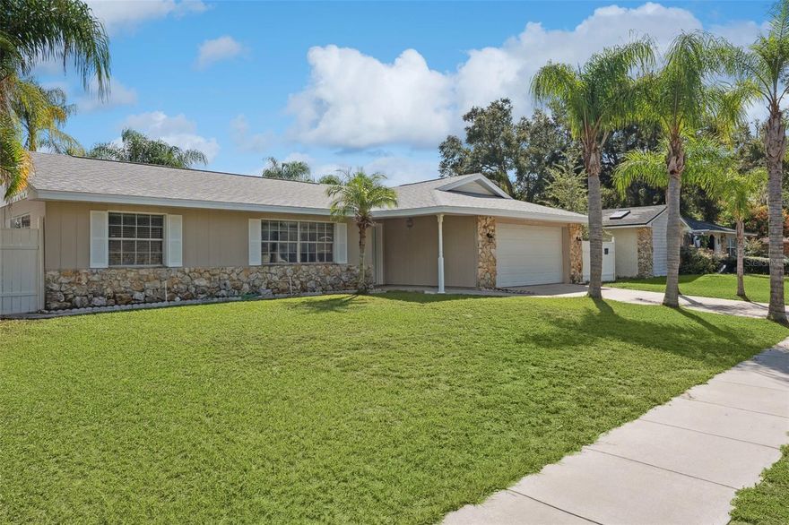 This beautifully updated Conway home offers fantastic curb appeal – with a stone facade, lush lawn and towering palm trees that line the driveway and accent the backyard. Inside the front door, you’ll find updates throughout with wood-look, Spanish porcelain tile floors, crown molding, a neutral color palette and lots of natural light. The renovated eat-in kitchen is open to both the living & family rooms on either side. The kitchen features beautiful granite countertops, stainless steel appliances, recessed lighting, a tile backsplash and a breakfast bar. Just steps away, you can grill up dinner and entertain in that expansive screened-in lanai. The fenced-in yard offers a screened in, oversized patio & mature palm trees that provide a wall of privacy. Back inside, the isolated primary bedroom includes an updated ensuite with a custom-tiled shower and a new marble-topped vanity. The hallway bathroom has all the same finishes as the primary and the attached garage offers laundry & storage. This desirable Conway-area neighborhood has no HOA and is close to Lake George and Barber Park (dog park, skate park, hockey rink, picnic areas & sports fields). You’ll also be close to all the shopping & dining along Rt 436 to the North and Hoffner Ave to the South. You can be downtown in less than 15 mins or catch a flight at the airport in just 10 mins!