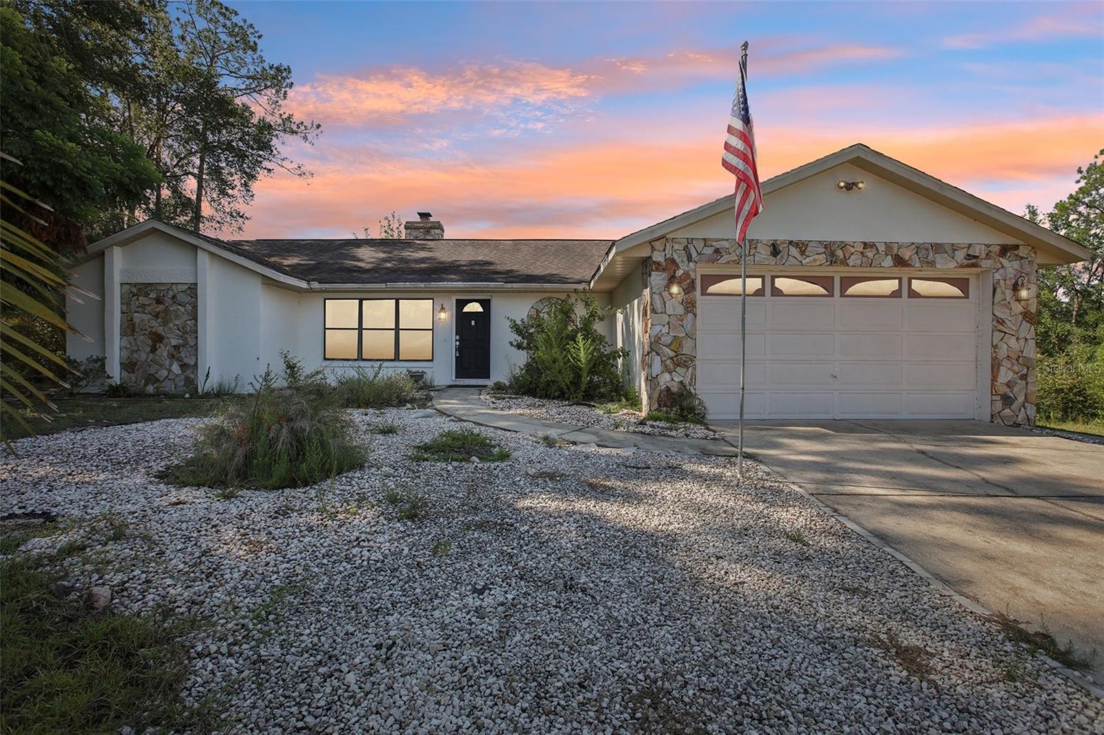 Welcome to this charming 3-bedroom, 2-bathroom home in the heart of Citrus Springs, offering 1,511 square feet of living space on nearly half an acre. This property comes with two lots, giving you the unique opportunity to enjoy extra space, sell the additional lot, or keep it for future possibilities. Step inside to an open floorplan where the living room greets you with soaring vaulted ceilings and a stunning stone fireplace that sets the perfect focal point. Just off the living room, you’ll find a cozy dining nook and a spacious kitchen featuring abundant cabinet and counter space, a breakfast bar, and brand-new appliances. The primary suite offers a walk-in closet, an en suite bathroom with a large vanity and walk-in shower, plus its own private sliding glass doors leading to the lanai. Additional highlights include new vinyl flooring, fresh carpet in the bedrooms, updated paint and lighting, a newer roof, and a newer A/C system. Step outside to enjoy the expansive covered and screened-in lanai overlooking the spacious backyard, perfect for relaxing or entertaining. With nearly half an acre, there’s plenty of room to enjoy the outdoors. This home is conveniently located near golf courses, nature trails, shopping, and dining, making it a wonderful place to call home. Mortgage savings may be available for buyers of this listing.