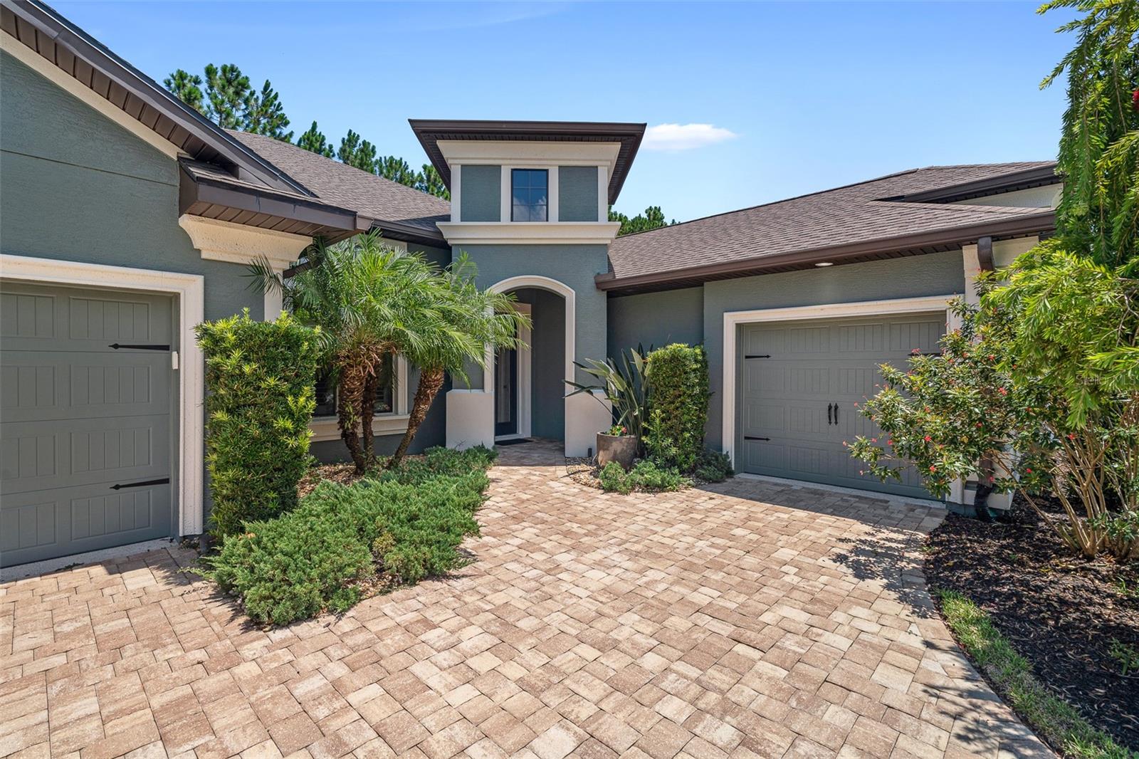 This beautifully upgraded Cameron floor plan is located on a preserve lot in the gated, golf-cart friendly community of Plantation Bay. With 3 bedrooms plus a private office, 2.5 baths, and a screened-in pool and spa under a massive mega screen enclosure, this home offers luxury living both inside and out. Once inside, you're welcomed by a spacious foyer that opens to a private office with glass French doors and wood-look tile. In hallway, there are sleek floating cabinets with a stylish pass-through, and soaring ceilings that immediately showcase the home's thoughtful design and grand sense of space. The open-concept layout showcases soaring 12-foot ceilings, tray ceiling with crown molding, and a striking stacked stone double-sided gas fireplace that serves as a dramatic focal point, connecting the vaulted sunroom to the main living area, where triple sliders and transom windows open to the lanai. The gourmet kitchen boasts 42-inch soft-close wood cabinets, granite countertops, a large island with pendant lighting, travertine backsplash, 2 year old stainless steel appliances including Bosch dishwasher, double oven range, reverse osmosis system at the sink, and a walk-in pantry with custom shelving, all flowing seamlessly into a dining space with plantation shutters and easy lanai access. Step outside to your private backyard oasis with travertine decking, a heated pool with integrated spa, and a preserve view offering ultimate privacy. Under you covered lanai is built-in prep station with ice bin, cutting board, and trash compartment makes this the perfect space for an outdoor bar or entertaining area. The spacious primary suite includes a tray ceiling, wood-look tile, plantation shutters (throughout entire home) and a luxurious en-suite with soaking tub, split vanities with granite, a walk-in shower, and a custom walk-in closet. Split floor plan with two guest bedrooms sharing a Jack-and-Jill bath with granite counters, tiled tub/shower combo. Additionally, a stylish half bath with pedestal sink adds extra convenience. The laundry room includes LG washer and dryer, sink, and 32-inch upper cabinets with additional storage space in the stop-and-drop area off the one-car garage. The 2 car/1 car split garages feature epoxy floors, and the home includes an electric hybrid water heater, whole-house water filtration and softener system, and a new AC compressor (2025). The exterior is just as impressive with a paver driveway and walkway, rock bed landscaping, professional curbing, and a split 3-car garage for elevated curb appeal. All located in GATED, golf cart friendly community of Plantation Bay Golf and Country Club. Optional memberships available to include 45 holes of private golf, 10 pickleball courts, 9 tennis courts, new 30-million-dollar Founders clubhouse, additional Prestwick Clubhouse, fitness/spa center, bocce ball, clubhouse with cabana bar and grill, and full activities calendar. Buyers of this home are to receive a substantial discount on the initiation fee at the club. Ask the listing agent for details. This is Florida luxury living at its finest, move-in ready and waiting for you!