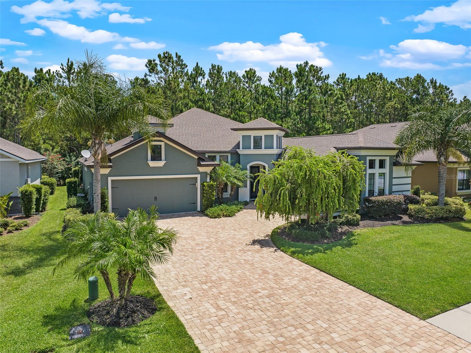 This beautifully upgraded Cameron floor plan is located on a preserve lot in the gated, golf-cart friendly community of Plantation Bay. With 3 bedrooms plus a private office, 2.5 baths, and a screened-in pool and spa under a massive mega screen enclosure, this home offers luxury living both inside and out. Once inside, you're welcomed by a spacious foyer that opens to a private office with glass French doors and wood-look tile. In hallway, there are sleek floating cabinets with a stylish pass-through, and soaring ceilings that immediately showcase the home's thoughtful design and grand sense of space. The open-concept layout showcases soaring 12-foot ceilings, tray ceiling with crown molding, and a striking stacked stone double-sided gas fireplace that serves as a dramatic focal point, connecting the vaulted sunroom to the main living area, where triple sliders and transom windows open to the lanai. The gourmet kitchen boasts 42-inch soft-close wood cabinets, granite countertops, a large island with pendant lighting, travertine backsplash, 2 year old stainless steel appliances including Bosch dishwasher, double oven range, reverse osmosis system at the sink, and a walk-in pantry with custom shelving, all flowing seamlessly into a dining space with plantation shutters and easy lanai access. Step outside to your private backyard oasis with travertine decking, a heated pool with integrated spa, and a preserve view offering ultimate privacy. Under you covered lanai is built-in prep station with ice bin, cutting board, and trash compartment makes this the perfect space for an outdoor bar or entertaining area. The spacious primary suite includes a tray ceiling, wood-look tile, plantation shutters (throughout entire home) and a luxurious en-suite with soaking tub, split vanities with granite, a walk-in shower, and a custom walk-in closet. Split floor plan with two guest bedrooms sharing a Jack-and-Jill bath with granite counters, tiled tub/shower combo. Additionally, a stylish half bath with pedestal sink adds extra convenience. The laundry room includes LG washer and dryer, sink, and 32-inch upper cabinets with additional storage space in the stop-and-drop area off the one-car garage. The 2 car/1 car split garages feature epoxy floors, and the home includes an electric hybrid water heater, whole-house water filtration and softener system, and a new AC compressor (2025). The exterior is just as impressive with a paver driveway and walkway, rock bed landscaping, professional curbing, and a split 3-car garage for elevated curb appeal. All located in GATED, golf cart friendly community of Plantation Bay Golf and Country Club. Optional memberships available to include 45 holes of private golf, 10 pickleball courts, 9 tennis courts, new 30-million-dollar Founders clubhouse, additional Prestwick Clubhouse, fitness/spa center, bocce ball, clubhouse with cabana bar and grill, and full activities calendar. Buyers of this home are to receive a substantial discount on the initiation fee at the club. Ask the listing agent for details. This is Florida luxury living at its finest, move-in ready and waiting for you!