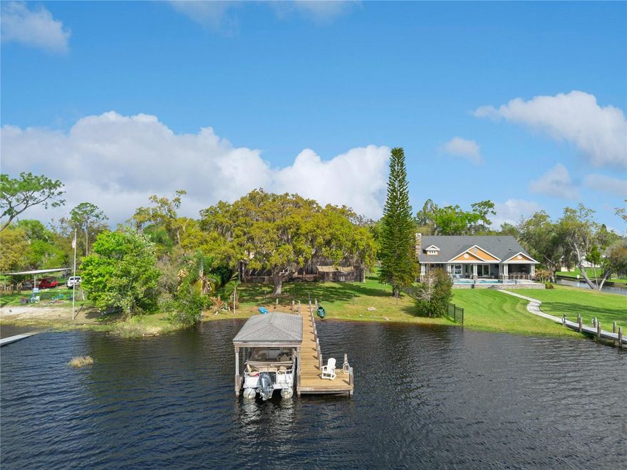 **Appraisal Completed for Buyer, Price Updated**
Set beneath a canopy of majestic oak trees on nearly one acre of pristine lakefront, this exceptional custom estate offers the perfect balance of privacy, flexibility, and waterfront living on Lost Lake (Coon Lake)—part of the highly coveted Alligator Chain of Lakes.

Built in 2008, the property features a spacious main residence plus a private guest retreat, totaling 5,297 square feet of living space and more than 8,100 square feet under roof. The main home offers four bedrooms, three and a half baths, and a three-car garage, with thoughtful architectural details and sweeping lake views from multiple rooms and a serene second-floor balcony.

Designed for both comfortable living and entertaining, the interior showcases generous gathering spaces, a gas fireplace, a formal dining room with a coffered ceiling, and a beautifully updated kitchen (2024) featuring new granite countertops, backsplash, Z-Tech cooktop, and double smart ovens with wireless controls.

The luxurious primary suite serves as a true retreat, complete with two oversized walk-in closets—one built as a reinforced safe room—and a spa-inspired bath featuring a hydromassage tub, dual vanities, and a separate shower.

Upstairs, discover even more versatility with a large bonus/game room and a private home theater, fully equipped with a projector, screen, and sound system, all included with the sale.

A standout feature is the detached guest residence located above a second three-car garage. Approx. 1,200 square feet, this private apartment includes a full kitchen, living and dining areas, oversized bedroom (easily convertible to two), full bath, and an additional half bath on the garage level—ideal for extended family, guests, rental income, or a private home office or studio.
Outdoor living is equally impressive. Enjoy approximately 1,500 square feet of covered and open lanai and patio space, perfect for entertaining or unwinding while taking in peaceful lake views. The lush backyard also features a custom koi pond with a waterfall and approximately 30 koi fish (estimated value $10,000–$15,000), creating a tranquil, resort-style atmosphere.
For boating enthusiasts, the private dock with boat lift and new motor provides direct access to the Alligator Chain of Lakes, offering endless opportunities for boating, fishing, and recreation.
Major upgrades include a new roof (2024), new main HVAC system (2024), a second Carrier Infiniti system (approx. 6 years old), and updated drain lines. With two separate three-car garages, no HOA, mature landscaping, fruit trees, and close proximity to Harmony, Melbourne, St. Cloud, and Lake Nona, this property offers a rare opportunity to enjoy expansive lakefront living with everyday convenience.
A truly unique estate where space, lifestyle, and location come together.