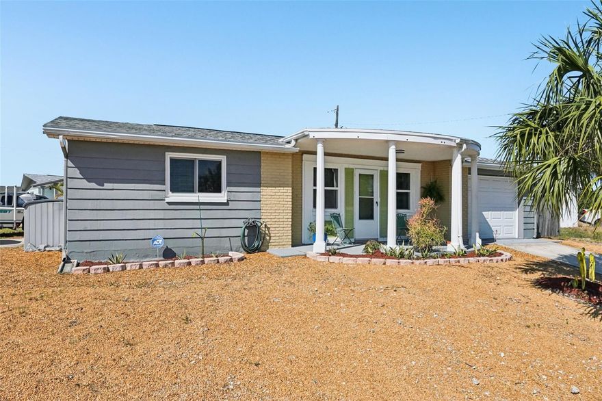 Welcome home to this terrific coastal retreat in the highly desirable Beacon Square community of Holiday, FL. This beautifully renovated home sits on a uniquely elevated corner lot—offering the rare peace of mind of staying dry and avoiding flooding—with the added convenience of driveway access on both sides of the property. Inside, you’re greeted by a charming, open-concept floor plan that flows seamlessly from the entrance into a spacious kitchen boasting granite countertops, a mosaic backsplash, and updated cabinetry. Enjoy the cozy wood-burning fireplace adjacent to the oversized, climate-controlled Florida room that provides the perfect versatile space. Every detail has been meticulously updated for a move-in-ready experience, including a newer Goodman AC (2019), Pella Impact-resistant windows (2022), updated wiring, a two-year-old water heater, and a recently remodeled bathroom. Beyond the interior, you’ll find a private fenced backyard, a handy three-quarter bath in the garage, and an included generator for total preparedness. With no HOA or CDD fees to worry about, you are perfectly positioned to enjoy nearby gems like Key Vista Park, the Pinellas Trail, and local fishing piers, beaches, and golf courses.