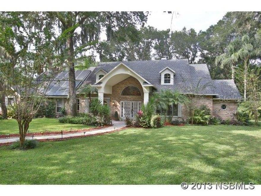 Located in the prestigious gated, fly-in and golf community of Spruce Creek Fly-In, this wonderful 5 bedroom, 4.5 bath family pool home is uniquely set on an acre lot. One of the larger lots in the community, it is private, buffered from the street and backs to the Spruce Creek. Spruce Creek leads to the Intracoastal waterway. The park-like landscape provides beautiful and natural surroundings to enjoy all year long. This two-story home has welcoming entry foyer with staircase, hardwood floors and views straight out through the great room's wall of windows at the rear. The great room features gas fireplace, 2 story height ceiling with open banister and includes the spacious chef's kitchen. Entertaining is a delight with its large breakfast bar, center island, walk-in pantry, granite countertops, stainless steel appliances including matching SUBZERO refrigerator and freezer. A butler's pantry leads to the formal dining room. The first floor master suite has separate vanity area, large master bath with granite countertops, jetted garden tub and tiled shower. A dream size closet plus an additional attached bonus room could serve a variety of purposes. Upstairs are 2 large bedrooms each with balconies looking to rear woods, 2 full baths plus 2 additional bedrooms. A media room is off the main great room and kitchen. It has views to the pool and an attached full bath and sauna that are also easily accessible from the pool and oversized two car, side entry garage ;Water: City