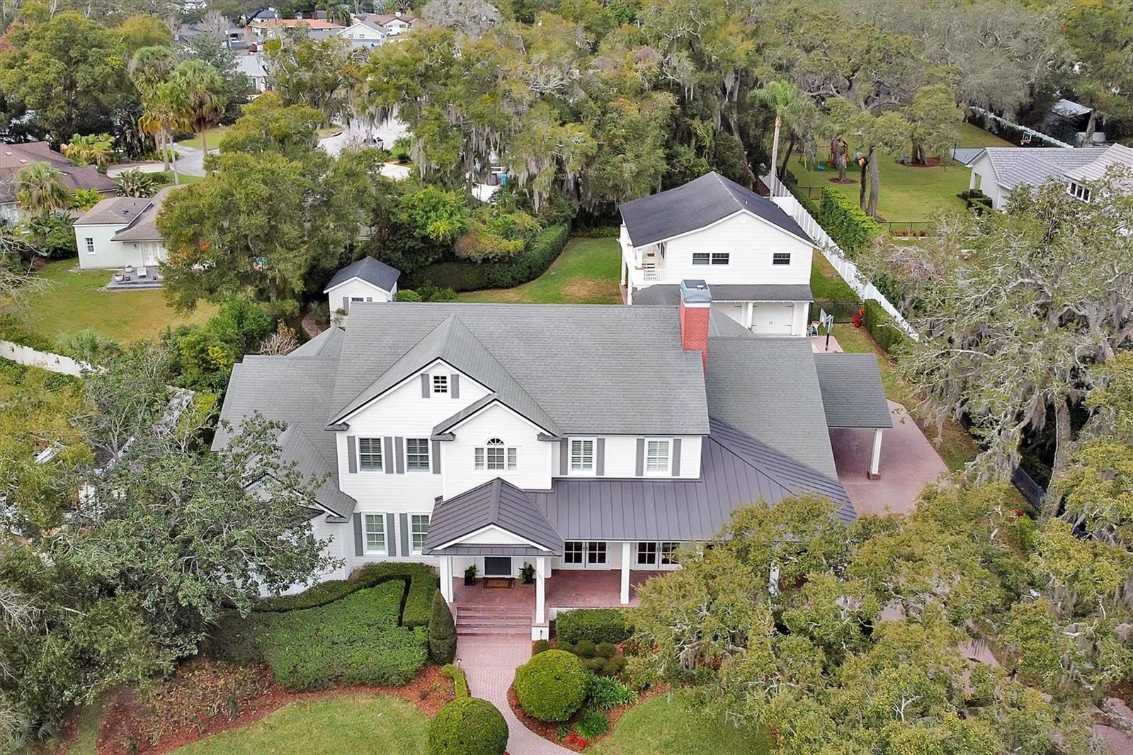 Stunning boat/ski lakefront home w 5,697sf on 1.5+- upland acres. 5 bed 4.5 bath w detached 1,100sf guest house over 3 car garage. Minutes from downtown Winter Park/Park Ave upscale shopping & dining. 10-minute drive to downtown Orlando. Features: gourmet kitchen, pool/spa, summer kitchen, expansive storage, lakefront views. The open concept kitchen is a true chef's delight featuring every accoutrement your heart would desire. A state-of-the-art refrigerator and freezer, double ovens, Ice maker, 2 wine/beverage fridges with a gourmet cook top, massive granite island and walk in pantry. This lovely kitchen is adjacent to the large family room and bonus room that each look out on to beautiful lake Sybelia. The downstairs flooring is a warm wide planked wood while the entrance and hall includes stunning large travertine tiles. The downstairs primary bedroom provides a private retreat of tranquility with breathtaking lake views as well as a large primary bathroom and walk in closet. You’ll find four substantial sized bedrooms and 2.5 baths upstairs with a bonus gamer room, study area and upstairs 2nd laundry room. The large front yard and lake views aren’t the only outdoor highlights the expansive property has to offer. You’ll enjoy entertaining and grilling in the large, covered summer kitchen or enjoy swimming in the beautiful crystal blue pool. It’s a gardeners delight with three large garden boxes and huge storage shed. There is also a large courtyard, half-court basketball court in addition to the shady large, grassed back yard. It’s truly a family home with tons of wonderful, usable and thoughtfully designed spaces with something for everyone to enjoy. Even your cars will be delighted with the oversized three car garage with extra space for a home gym as well. Come discover what living in Maitland is all about. This private and secluded street is a true gem as it offers privacy and an escape from bustling Orlando, yet minutes away from fine dining, top rated schools, parks and boutique shopping. This special home will provide the backdrop for many wonderful family memories to come. Schedule your private tour today and you’ll quickly see just what the epitome of luxury family living in gorgeous Maitland is all about.