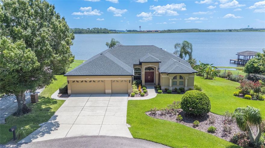 Welcome to this stunning 4-bedroom, 2.5-bath lake front home located in the highly sought-after Sandy Pointe community of Polk City, FL. Perfectly situated on a premier half-acre lot at the end of a cul-de-sac, this property offers privacy, tranquility, and breathtaking views of Big Lake Agnes. Known for its excellent fishing and boating, the lakefront setting provides a lifestyle of peace and recreation. Imagine sitting on your lanai watching sunrises in the morning and the moonrise at night reflected over the water. Step inside to discover soaring 11-foot ceilings in the formal living room, dining room, master suite, kitchen, and family room, creating an open and airy atmosphere. The home also features 9.2-foot ceilings in the additional three bedrooms, laundry room, and bathrooms for a spacious flow throughout. The formal dining room and formal living room both showcase cherry laminate flooring and double sliders leading out to the lanai with expansive lake views. The master suite includes double sliding glass doors overlooking the lake, his-and-her walk-in closets, and a luxurious bath with separate vanities. The kitchen boasts 40-inch cabinets, granite countertops (updated in 2020), and a breakfast nook with a large picture window and custom wood blinds. In the family room, enjoy a gas fireplace, custom window treatments, and sliders that open to the lanai and lake view. The oversized 24x24 screened lanai is perfect for entertaining, featuring two ceiling fans and a 220-volt outlet ready for a spa. Outside, enjoy a beautifully landscaped yard with lake-fed irrigation, four hose bibs, and plenty of space to relax. A highlight of this property is the 95-foot dock with a boat house, boat cradle, and sundeck, making lakefront living truly enjoyable. Additional features include a 3-car garage, a new air conditioning system (2016), and a new roof (2017), providing peace of mind. The home is part of a welcoming community with a private boat ramp and low HOA dues. With its serene setting, elegant features, and direct lake access, this property is a rare find. Don’t miss the opportunity to experience lakefront living at its finest on Big Lake Agnes—schedule your private showing today