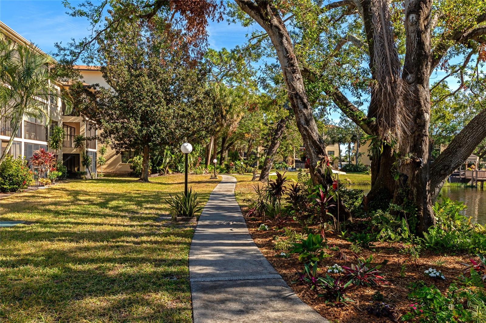 **Priced BELOW Market Value** Welcome to this charming 2-bedroom, 2-bathroom ground-floor corner unit in the highly desirable Desoto Square Villas community. Nestled in a serene, park-like setting, this home offers views of lush greenery and a tranquil pond, creating the perfect backdrop for relaxation and peaceful living.
As you step inside, you'll immediately notice the bright, open floor plan, with natural light streaming in through large glass doors that frame the picturesque views of the courtyard and pond. The spacious living area seamlessly connects to the dining and kitchen spaces, offering an ideal layout for entertaining and everyday living. The kitchen is well-equipped with modern appliances, ample cabinetry, and plenty of counter space.
The master suite is a private retreat, featuring an en-suite bathroom for added convenience. The second bedroom is equally spacious and provides easy access to the second full bathroom. Both bedrooms are located on the open side of the unit meaning NO neighbors/shared wall.
Step outside to your private lanai and immerse yourself in the beauty of the community's park-like grounds, where you can relax and enjoy the sights and sounds of the pond.
Desoto Villas offers fantastic amenities including a sparkling pool, clubhouse, and sports courts, perfect for recreation and socializing. The community is gated, providing a secure and peaceful environment. Enjoy a quiet, residential atmosphere while being conveniently located near shopping, dining, and entertainment options. Don’t miss the opportunity to make this beautiful, serene condo your own!