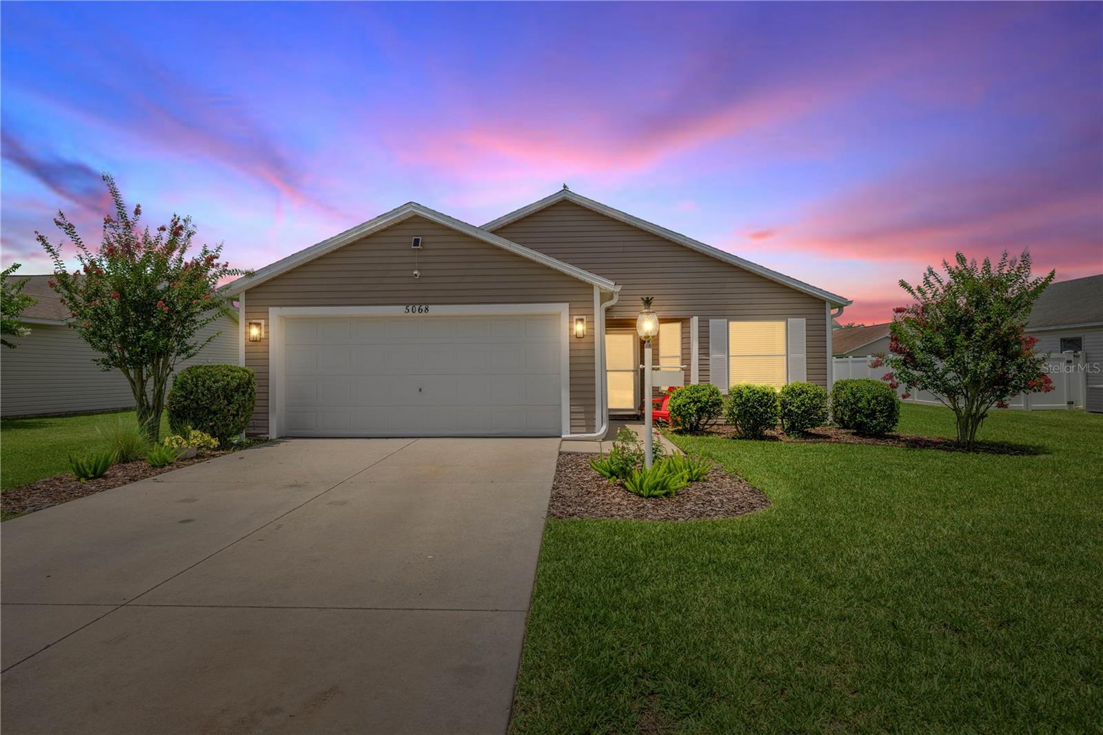 Prime Location Near The Villages Charter School! Easy golf cart assessable to all The Villages offers. Welcome to this beautifully maintained 3-bedroom, 2-bath At Ease model home, complete with a 2-car garage, located in the highly sought-after family-friendly neighborhood of Bison Valley. Just under a mile from The Villages Charter School and close to CR 466, providing easy access to the area’s most popular restaurants, shops, and essential services. This home offers the perfect blend of comfort, convenience, and lifestyle. Step inside and immediately feel at home with luxury vinyl plank flooring throughout—no carpet, fresh paint, and soaring ceilings that create a bright, airy atmosphere. The spacious open-concept layout is perfect for both everyday living and entertaining. The kitchen is a standout feature with light cabinetry, a stylish backsplash, new light fixtures, stainless steel appliances, and a large farmhouse-style sink. The indoor laundry room offers plenty of space and storage. The guest bathroom is smartly placed near the guest bedroom, providing privacy and functionality. The master suite is a true retreat, featuring vaulted ceilings, a lighted ceiling fan, a spacious walk-in closet, and an ensuite bath with dual sinks and ample counter space. Step out through the sliding glass doors onto a screened lanai, ideal for morning coffee or relaxing evenings. Just beyond is a concrete patio slab, perfect for grilling and outdoor gatherings. The lush backyard and blooming crepe myrtle tree out front add charm and curb appeal.
Live minutes from shopping, dining, and entertainment near CR 466 and at Lake Sumter Landing. Whether you’re raising a family or looking for a peaceful neighborhood with easy access to The Villages, this home checks all the boxes!
