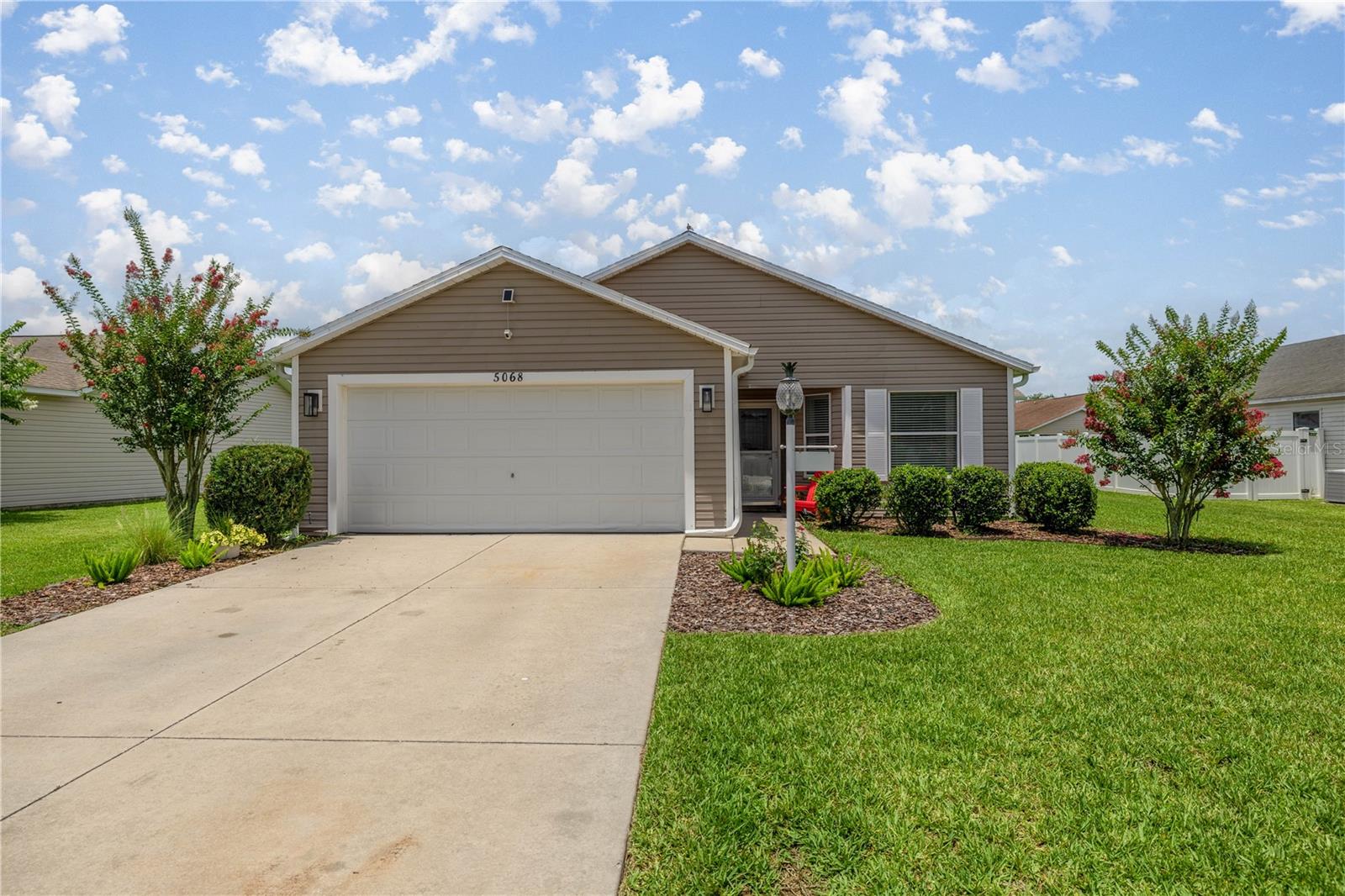Prime Location Near The Villages Charter School! Easy golf cart assessable to all The Villages offers. Welcome to this beautifully maintained 3-bedroom, 2-bath At Ease model home, complete with a 2-car garage, located in the highly sought-after family-friendly neighborhood of Bison Valley. Just under a mile from The Villages Charter School and close to CR 466, providing easy access to the area’s most popular restaurants, shops, and essential services. This home offers the perfect blend of comfort, convenience, and lifestyle. Step inside and immediately feel at home with luxury vinyl plank flooring throughout—no carpet, fresh paint, and soaring ceilings that create a bright, airy atmosphere. The spacious open-concept layout is perfect for both everyday living and entertaining. The kitchen is a standout feature with light cabinetry, a stylish backsplash, new light fixtures, stainless steel appliances, and a large farmhouse-style sink. The indoor laundry room offers plenty of space and storage. The guest bathroom is smartly placed near the guest bedroom, providing privacy and functionality. The master suite is a true retreat, featuring vaulted ceilings, a lighted ceiling fan, a spacious walk-in closet, and an ensuite bath with dual sinks and ample counter space. Step out through the sliding glass doors onto a screened lanai, ideal for morning coffee or relaxing evenings. Just beyond is a concrete patio slab, perfect for grilling and outdoor gatherings. The lush backyard and blooming crepe myrtle tree out front add charm and curb appeal.
Live minutes from shopping, dining, and entertainment near CR 466 and at Lake Sumter Landing. Whether you’re raising a family or looking for a peaceful neighborhood with easy access to The Villages, this home checks all the boxes!