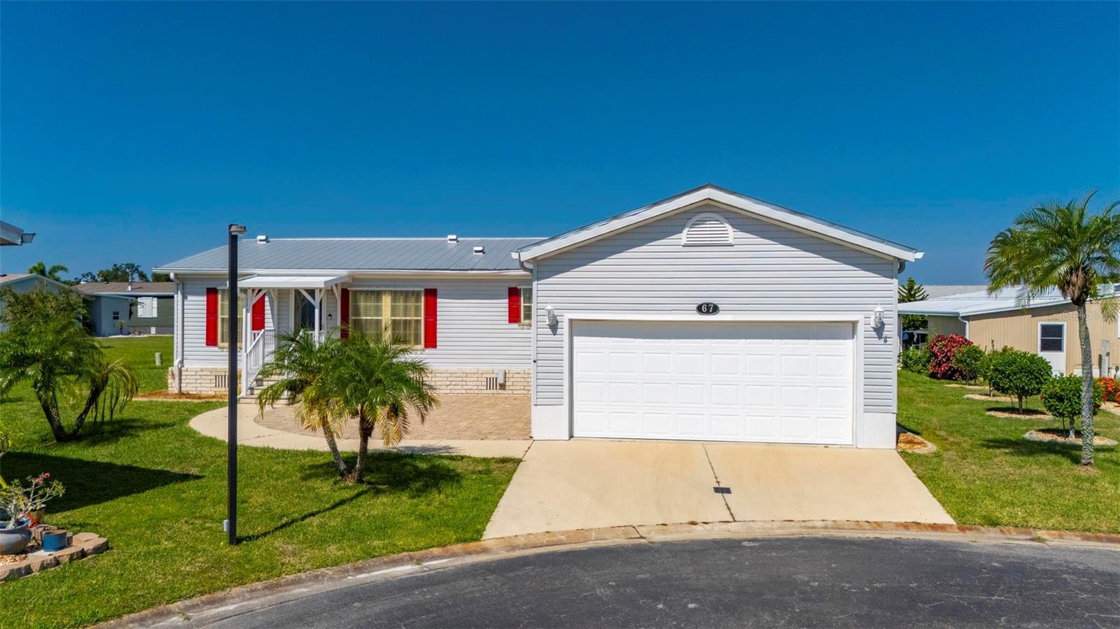 This beautifully furnished 3-bedroom, 2-bath manufactured home with an oversized 2-car garage is the perfect blend of luxury, functionality, and Florida charm. From the moment you arrive, you’ll notice the inviting paved front patio, ideal for outdoor relaxation or entertaining. Step inside to find a thoughtfully designed interior featuring full drywall construction, elegant crown molding, custom window treatments, and high-end furniture throughout. The desirable split floor plan provides privacy and flow, with a spacious primary suite separated from the guest bedrooms.
The heart of the home is the large, light-filled eat-in kitchen, complete with stainless steel appliances, solid wood cabinetry with pull-out drawers, and ample space for casual dining. A formal dining room adds to the functionality and charm, perfect for hosting guests. All three bedrooms are spacious, with generous closet space. The third bedroom is especially versatile, offering a built-in desk, Murphy bed, and custom closet, making it ideal for a home office or guest suite.
The oversized 2-car garage is a true standout, featuring a vented 10-foot ceiling—perfect for storage, a workshop, or hobby space. Additional highlights include a durable metal roof, a complete HVAC system installed in 2023, a whole-home generator, and an exterior generator hookup for added peace of mind.
This home is situated in a prime location close to elite golf courses, top-rated restaurants, shopping, entertainment, scenic fishing spots, and the beautiful blue waters of Florida’s beaches. Whether you're looking for a seasonal retreat or a year-round residence, this meticulously maintained home is move-in ready and designed to impress.