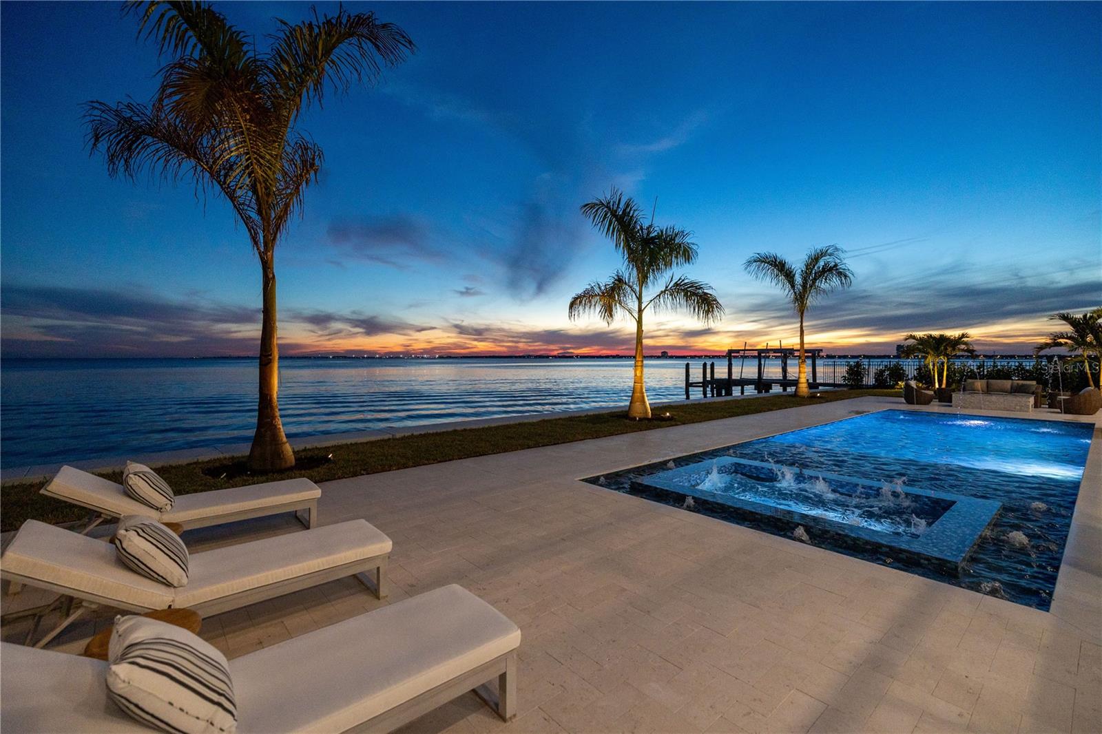 Pure Magnificence awaits in this Ultra-Luxury Modern Coastal gated estate in the coveted community of Davis Islands boasting waterfront grandeur, spectacular views, and captivating sunsets year-round. Positioned on one of the largest Bayfront parcels available in the Tampa Bay area, with 110 feet of bay frontage, and featuring over 9,442 SF Under Air / 19,644 Total Square Ft which includes a 5300+ Square Ft garage level with parking for 10+ cars. This brand-new construction built by Boss and Mennie Luxury Homebuilders delivers the latest design, and built to the latest building codes with concrete block/piling construction, impact windows/doors, and elevated FEMA-compliant living for flood risk reduction. Featuring a unique and rarely found rooftop terrace with ample entertaining space that delivers 360 degree awe-inspiring views of Tampa Bay, Bayshore Boulevard and the Tampa Skyline. .From the circular drive to the grand two-story foyer, an expansive great room welcomes you to decadent light-filled living spaces, two-story windows/full wall pocketing doors, and terrace access, with sweeping water views at every turn. Offering a dramatic dual-sided fireplace, a formal dining room with impressive wine display/storage, an impeccable chef’s kitchen with Calacatta Quartz countertops, top-of-the-line Wolf & Sub-Zero appliances, breakfast area overlooking the water, a butler’s pantry, coffee station and waterfront terrace access. Designed for optimum entertaining with a full entertaining bar/lounge, covered terrace and outdoor fireplace, dedicated home theater. The 2 first-floor ensuite guest bedrooms offers privacy in the front of the home, with flexible space affording a den/office. An upper level grand primary retreat offers the ultimate in privacy and luxury with access to a private covered waterfront terrace, morning bar, tranquil seating area and large custom executive closets/dressing area. The sumptuous spa-inspired primary bath delivers a prominent soaking tub and water view, an expanded full glass shower with steam and 2 separate water closets. The laundry room provides dual washers & dryers with access from both the hall and the primary bedroom. There are 3 additional ensuite guest bedrooms on the third level, with one waterfront guest bedroom providing a Jr. Master suite and access to a covered terrace. Enjoy the very best of waterfront living and outdoor entertaining on a gracious covered lanai featuring an outdoor kitchen, dining area, waterfront custom pool and spa. An allowance is included for a custom dock with a boat lift built to the buyer’s specifications. Additional appointments include a 4-stop elevator, coffered ceilings, wide plank oak flooring, a 38KW Natural Gas generator, tankless water heaters, gas appliances, LED lighting, and secured gated entry, and full under building drive through garage plus storage area. The envied Davis Islands lifestyle provides an array of recreation both on and off the water. Residents enjoy a sailing and yacht club, private airport, tennis complex, community pools, garden club, Davis Islands Beach, parks and more. The Davis Islands Village features a “main street” feel with dining, coffee shops, yet remains near downtown Water Street Tampa, Amalie Arena and Riverwalk. A-rated schools and convenience to sports venues, recreation, shopping, dining and entertainment, this is the essence of the exceptional Tampa Bay Waterfront Living.