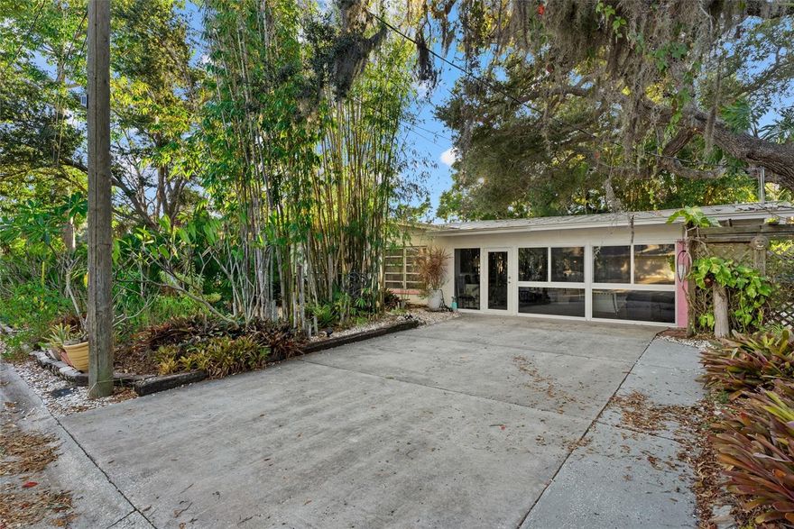 Mid-Century Modern luxury meets lush coastal living. Welcome to 2207 Hickory Avenue, an exquisitely updated Mid-Century Modern retreat in Sarasota’s Indian Beach–Sapphire Shores neighborhood, just west of the trail and moments from Sarasota Bay. On an oversized 10,000-plus-square-foot double corner lot, this turnkey residence offers a rare blend of timeless design, botanical tranquility and thoughtful modern enhancements.

Enter inside to original terrazzo floors that have been meticulously ground and polished to a brilliant finish, complemented by soaring 9-foot ceilings and a reimagined open floor plan. The main living space seamlessly flows into the heart of the home with a fully renovated chef’s kitchen featuring new stainless appliances, sleek cabinetry, quartz countertops, designer backsplash and a striking Chihuly-inspired chandelier. A fully enclosed and finished sunroom, now a bonus room, adds an additional 400 square feet of conditioned living space, complete with hurricane-impact sliders and windows, luxury vinyl plank flooring and a newly installed air-conditioning mini split. This is a space for relaxing with garden views, entertaining guests or working from home in peace. The outdoor setting is nothing short of botanical bliss. Surrounded by mature tropical landscaping, exotic bamboo and newly planted rare fruit trees, the property includes an outdoor shower, a hot tub under the palms and a private storage unit. A Tesla charging station, tankless water system and new electrical panel reflect the property’s modern sensibilities, while updated ductwork and new HVAC system ensure year-round comfort. Just a short stroll from Indian Beach and minutes to downtown Sarasota, St. Armands Circle and cultural treasures of Ringling Museum, this residence offers the ultimate in accessible, coastal Sarasota living. Offered fully furnished, including all Mid-Century Modern pieces and original artwork, this one-of-a-kind residence is move-in ready and ideal for buyers seeking sophistication, privacy and proximity to everything that makes Sarasota extraordinary.