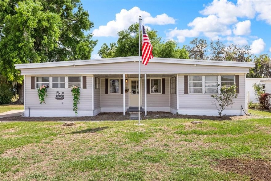Located in the peaceful lake area of Tavares, Florida, this charming home offers the perfect balance of comfort and privacy. This is an owned-land home with no leased land, situated in a quiet 55+ community at the back of the neighborhood. Competitively priced in the community, this home offers great potential for seasonal living as a winter retreat, an investment property, or a full-time residence. The open-concept kitchen, living, and dining areas create a seamless flow, while a unique split layout features a large covered and screened patio at the center, offering peaceful outdoor living with no rear neighbors and serene greenery views. This triple-wide home provides 1,014 square feet of heated living space on a 6,300-square-foot lot, plus a laundry room with a sink and an included washer and dryer. The property also offers extra storage, a workshop area, or a golf cart garage. Each of the 2 bedrooms has its own toilet room, and another half bathroom is located off the living room. Well-maintained and move-in ready, the home features laminate flooring throughout, stainless steel appliances, stone countertops, two refrigerators, and new upper kitchen cabinets added in 2022. The plumbing has been updated, and the HVAC system has been recently serviced. Roof work has been completed, and a foundation repair completed in 2025 provides added peace of mind. Additional features include a long driveway, a spacious covered front entry, an outdoor roofed mud/utility/grill area. This home may be sold with negotiable furniture and a golf cart. Situated in the Imperial Mobile Terrace West community with a low $25 monthly HOA, residents enjoy an array of amenities, including an indoor saltwater pool and hot tub, a clubhouse, a library, pool table, shuffleboard table and outside courts, and a waterfront park with a fish-cleaning station and canal access via a boat ramp. For an additional fee, you can use a trailer storage compound and marina slips. An active lifestyle is encouraged with social events such as dance classes and game nights. Conveniently located near dining, shopping, and medical facilities, the home is just minutes from downtown Tavares, Mount Dora, and local amenities like Publix and Lake Square Mall. This inviting home offers a rare opportunity to experience both comfort and community in a desirable location. Schedule your showing today and see all that this home has to offer.