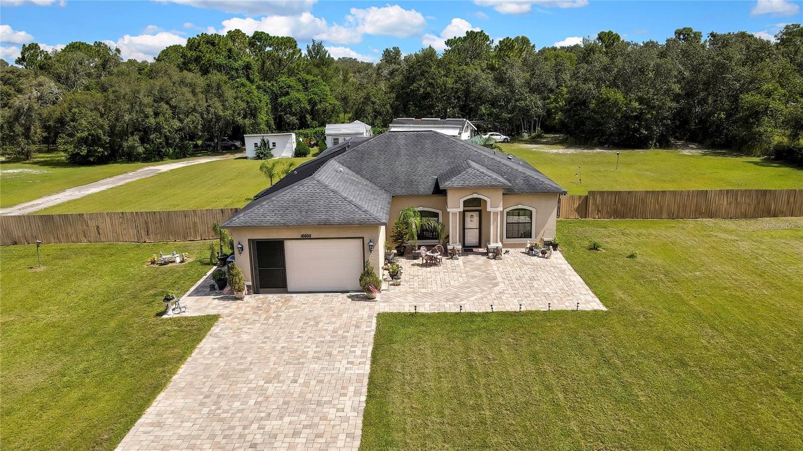 Escape to your own slice of serenity with this meticulously designed and maintained better than new custom pool home. This home sits on 1.6 acres that allows plenty of room to spread out. The driveway is extra long and custom pavered from the street to the front door. Allowing for a beautiful carefree courtyard entry area. Entering the home the Great room is expansive with high vaulted ceilings and beautiful french doors with custom side lights to the expansive lanai. The kitchen is huge with an area for your table. High end gas stove for the gourmet cook. Stainless steel refrigerator was just replaced. Granite counter tops with 42 inch cherry custom cabinets with pull out drawers and 2 spice drawers on each side of the stove. Master Bedroom has high 10 foot ceilings very spacious feeling with the lovely en-suite double vanity and extra large walk in shower. Two lovely guest bedroom and guest bath on opposite side of home with very spacious 10 foot ceilings. Outside you will find a lanai that is huge 46 long and 20 wide. Ceiling fan and cable for you TV. From their you can jump in your beautiful custom pool just completed in 2019 with solar heat for the cooler months. Enjoy your beautiful fully screened in Gazebo with ceiling fan under the stars at night. This home is located in an area famous for pigeon racers. This home comes with two Pigeon Coops and a shed.