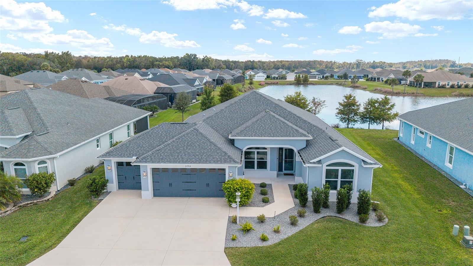 Welcome to your DREAM HOME situated in the highly coveted village of Hammock at Fenney. Highlighted by its natural setting, Hammock at Fenney boasts a resort-style zero-entry family pool, the popular Fenney Grill restaurant, two executive golf courses, a sports pool, pickleball courts and numerous other amenities. 
Enter this bright and beautiful home and be captivated by the gorgeous WATER AND NATURE VIEWS that greet you. The OPEN-CONCEPT FLOOR PLAN, HIGH CEILINGS and SLEEK AND MODERN DESIGN create a seamless flow throughout the living spaces. The expansive living and dining areas are filled with natural light. STACKING SLIDING DOORS lead to the STRETCHED LANAI, where the serene waterfront setting provides the ideal backdrop for unwinding or entertaining. 
The kitchen is a showstopper, adorned with LUXURIOUS QUARTZ COUNTERTOPS, TILE BACKSPLASH, 42-INCH CABINETRY, and sleek STAINLESS-STEEL APPLIANCES. There is plenty of counter and storage space, including roll-out drawers in the cabinets. 
Beautiful TILE PLANK FLOORING (no carpet) and UPGRADED LIGHT FIXTURES add warmth and sophistication to the space. 
The EXPANSIVE PRIMARY SUITE offers a private sanctuary, thoughtfully separated from the guest bedrooms. It boasts DUAL CUSTOM WALK-IN CLOSETS and a GENEROUS PICTURE WINDOW that beautifully showcases tranquil water views. The en-suite bath continues the theme of luxury with QUARTZ COUNTERTOPS and a spacious ROMAN SHOWER. 
Both guest bedrooms are nicely-sized with CUSTOM-DESIGNED CLOSETS. The laundry room has ample cabinet space and a utility sink. 
The EXPANDED TWO CAR, PLUS GOLF CAR GARAGE, complete with a durable EPOXY-COATED FLOOR, adds versatility and convenience.
Every detail of this exceptional home has been carefully curated for a lifestyle of comfort and a deep connection to nature. Shopping, dining, recreation and golf are all nearby. Location is conveniently situated between Brownwood Paddock Square and the upcoming Eastport, with both just minutes away. 
This MOVE-IN READY home is perfectly positioned in one of The Villages' most beautiful neighborhoods and is sure to be a favorite oasis for your family for years to come.