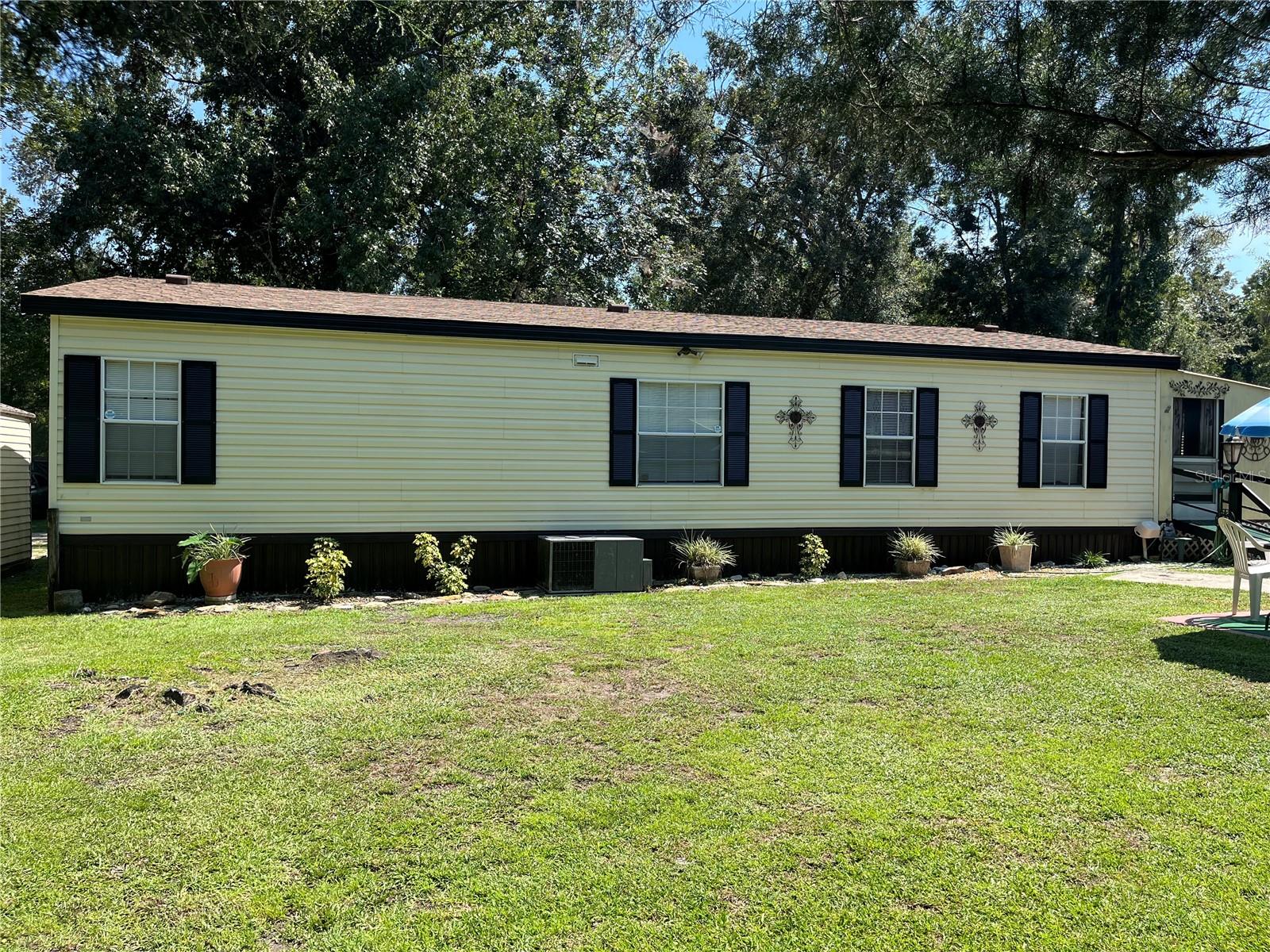 Don't miss out on this chance to own your own private oasis minutes from the heart of Downtown Brooksville! Nestled on a quiet dead end road and zoned for agriculture (AR2) this property is a homesteaders paradise. The spacious 1 acre lot features mature fruit and flower bearing trees, open spaces for future gardens, and plenty of room for chickens and small livestock. Inside you are welcomed by an open floor plan with vaulted ceilings. In the kitchen you will find an abundance of cabinetry, great counterspace for cooking and entertaining and updated appliances. The primary bedroom includes a walk-in closet and it's own large bathroom with step in shower. The back porch is climate controlled and offers a variety uses from a work out or crafting room to an office or guest space. Addition features to this charming property include a 2021 ROOF, 2 large sheds, separate carport, privacy fence and new washer and dryer. Don't let this one get away, call to schedule your showing today!!