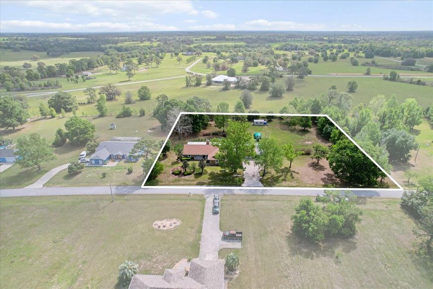 Welcome to your dream home, a stunning sanctuary nestled in the heart of the countryside. This captivating property sits on a generous 2.13 acres, including half of the adjoining vacant lot. This home boasts a split floor plan with 3 bedrooms & 2 bathrooms. Plus, a BONUS ROOM, offers versatility, it can easily serve as a home office or a 4th-bedroom with a SEPARATE ENTRANCE. With all NEW AC, & duct work installed in 2024, you can rest easy knowing your home is cool & efficient, plus a NEW ROOF in 2020! The home is also equipped with a state-of-the-art Alexa thermostat.  The FULLY FENCED backyard features a dedicated dog run, great for your furry friends to roam freely. The expansive yard is beautifully landscaped & features a fire pit, providing a picturesque setting & outdoor enjoyment. Explore your green thumb with a flourishing vegetable garden & a variety of fruit trees & plants, including fig, guava, plum, papaya, pear, lemon, tangerine, & more.  Enjoy gatherings with family & friends on the expansive paver patio or under the covered breezeway patio that connects the house to the detached 2-car garage & screened door. The HUGE ENCLOSED BACK PORCH, complete with vinyl windows, offers year-round enjoyment & leads to a soothing HOT TUB, wonderful for unwinding after a long day. The living room features a charming wood-burning stone fireplace. Cathedral ceilings amplify the spaciousness. With HURRICANE SHUTTERS, a WHOLE-HOUSE GENERATOR, a WATER SOFTENER & FOUR SHEDS that provide ample storage space, this home exudes functionality. Located in a small, rural neighborhood, this property offers the privacy of large lots while being just a stone’s throw from town amenities. This exceptional house is more than just a home; it’s a lifestyle. With its combination of modern conveniences, lush outdoor space, & stunning surroundings, it invites you to create cherished memories with family & friends for years to come. Don’t miss your chance to own this countryside gem, schedule a showing today & step into your new life!