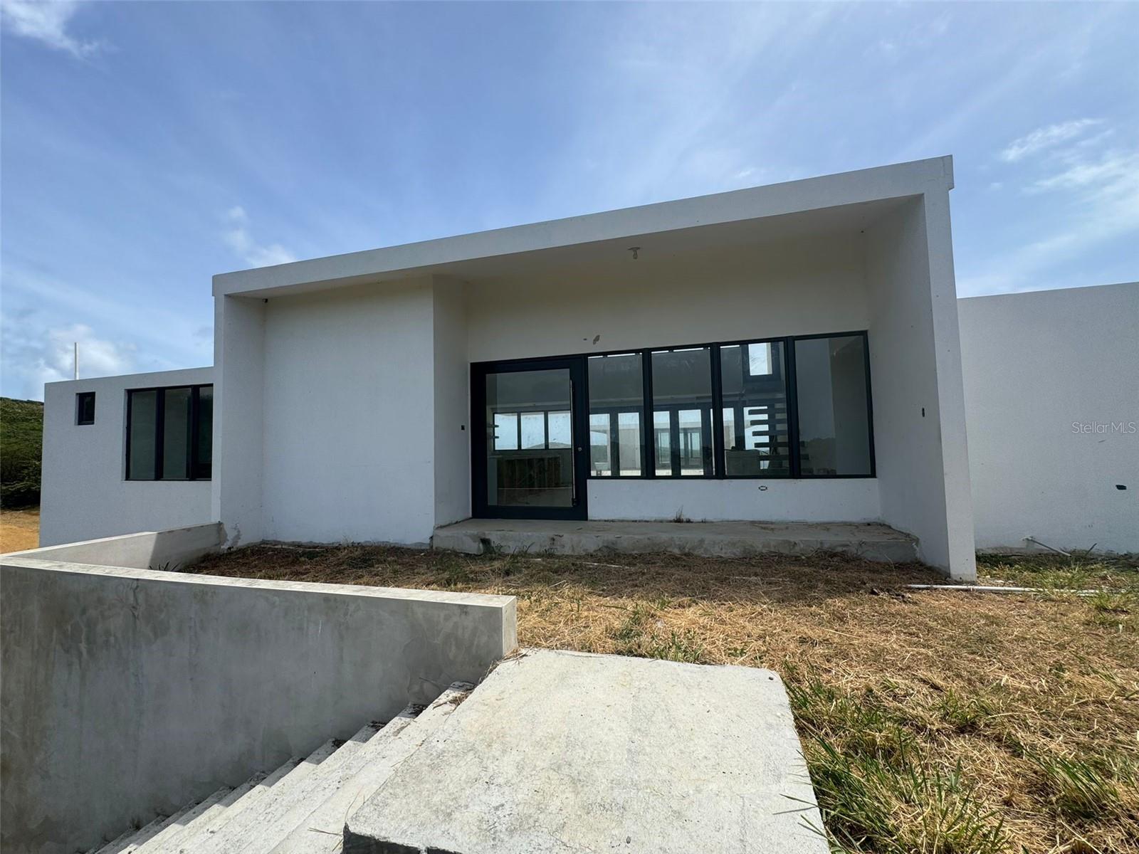 This property, Alturas de Zoni #8, is currently unfinished. The construction of the structure is complete but the inside of the house is not finished. The property is a blank slate for a Buyer to finish this beautiful home to their taste and desires. The full construction drawings and plans are available to complete the finishing work. The house is priced at a large discount whereas the purchase price plus cost to finish the house will be significantly lower than the resulting value of the completed property. The property is a spectacular 4000 square foot 5 bedroom, 4 bath luxury house on a 1 acre lot in the Zoni Beach area of the beautiful island of Culebra, Puerto Rico, one of the Spanish Virgin Islands. A unique opportunity for a one of a kind palatial home with breathtaking views. The views are the most sought after views on the Island of Culebra. The property looks out over the Island of Cayo Norte, the Island of Culebrita, the Island of St. Thomas, the Atlantic Ocean, the Caribbean Sea, Sail Rock, and on a clear day one can see to the British Virgin Islands.
The house on the property is comprised of two buildings, a front building and a back building with a pool/pool deck between the buildings. Both buildings are 100% poured concrete construction including the roofs. There is no concrete block, wood, nor other construction materials utilized in the construction of the house. The front building has an open design kitchen/dining/living great room, an upstairs mezzanine with outdoor porch, a garage, a Primary Suite with en-suite bathroom, 2 guest bedrooms (bedrooms 2 and 3), and an additional bathroom shared by the two guest bedrooms. The back building is a three story building. The top two floors, the second and third floors, of the back building each have a bedroom with en suite bathroom. The first floor of the back building is fully plumbed and wired so could easily be made the 6th bedroom/5th bathroom of the house if desired. Under the pool deck is a storage room and the 16,500 gallon rain water cistern. The storage area has been wired with electrical upgrades such that it could be converted into and utlized as a workshop.
The property is located in the Alturas de Zoni neighborhood of Culebra. The neighborhood is the most sought out premier neighborhood on the Island of Culebra consisting of 31 exclusive properties with the spectacular views noted above. The houses in the neighborhood are all luxury houses with minimum standards for design, size, and quality set and monitored by the Alturas de Zoni Homeowners Association Architectural committee.
By road the property is a half mile from Zoni beach which is the premier beach in Culebra touting the spectacular views mentioned above. Zoni beach is usually not occupied so at times one would have the beach all to themselves. At other times maybe up to 20 persons will be on Zoni beach.
The Alturas de Zoni neighborhood is about 5 miles from the town of Culebra. Far enough to "be away from it all" but close enough to be able to conveniently get to town for any services offered in town.
For beaches, the property is within 7 miles of all the beaches in Culebra.
For travel, the Culebra airport is just 4 miles from the property and the Culebra ferry dock is in town just 5 miles from the property.
All in all Alturas de Zoni #8 is a great luxury property in the most premier neighborhood on Culebra, a one of a kind.