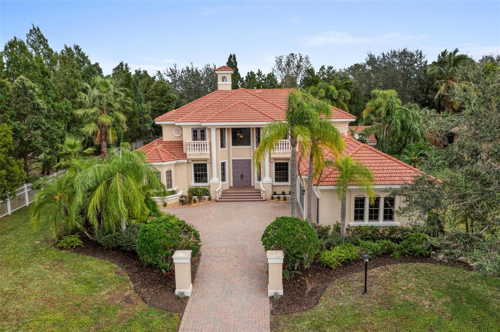 Sophistication, Seclusion, and the Ultimate Sarasota Address – Welcome to Lakewood Ranch Country Club
Tucked behind the gates of the gorgeous Lakewood Ranch Country Club, this Arthur Rutenberg-designed estate offers a rare blend of refined elegance, functional space, and complete privacy. From its striking Spanish/Mediterranean architecture to its thoughtfully designed floor plan, this home offers the perfect backdrop for upscale living.
Inside, you'll find five spacious bedrooms, a private office, bonus room, formal and informal living areas, and four full bathrooms—designed to accommodate everything from quiet relaxation to lively gatherings.
Step outside to your own secluded sanctuary: an oversized screened lanai, resort-style pool, and lush tropical landscaping surround you in tranquility—ideal for morning coffee, weekend entertaining, or peaceful evenings at home.
Enjoy the benefits of Lakewood Ranch Country Club living, including access to championship golf, tennis and pickleball courts, a state-of-the-art fitness center, and vibrant social events—all within a secure, beautifully maintained, guard-gated community.
Just minutes away lies the best of the UTC (University Town Center) District, offering upscale shopping, gourmet dining, Whole Foods, and entertainment options galore. And for those who crave culture and coast, downtown Sarasota, Siesta Key, Lido Key, and Longboat Key are just a short drive away.
This isn’t just a home—it’s an invitation to experience the very best of Florida living in a setting that offers both luxury and peace of mind.