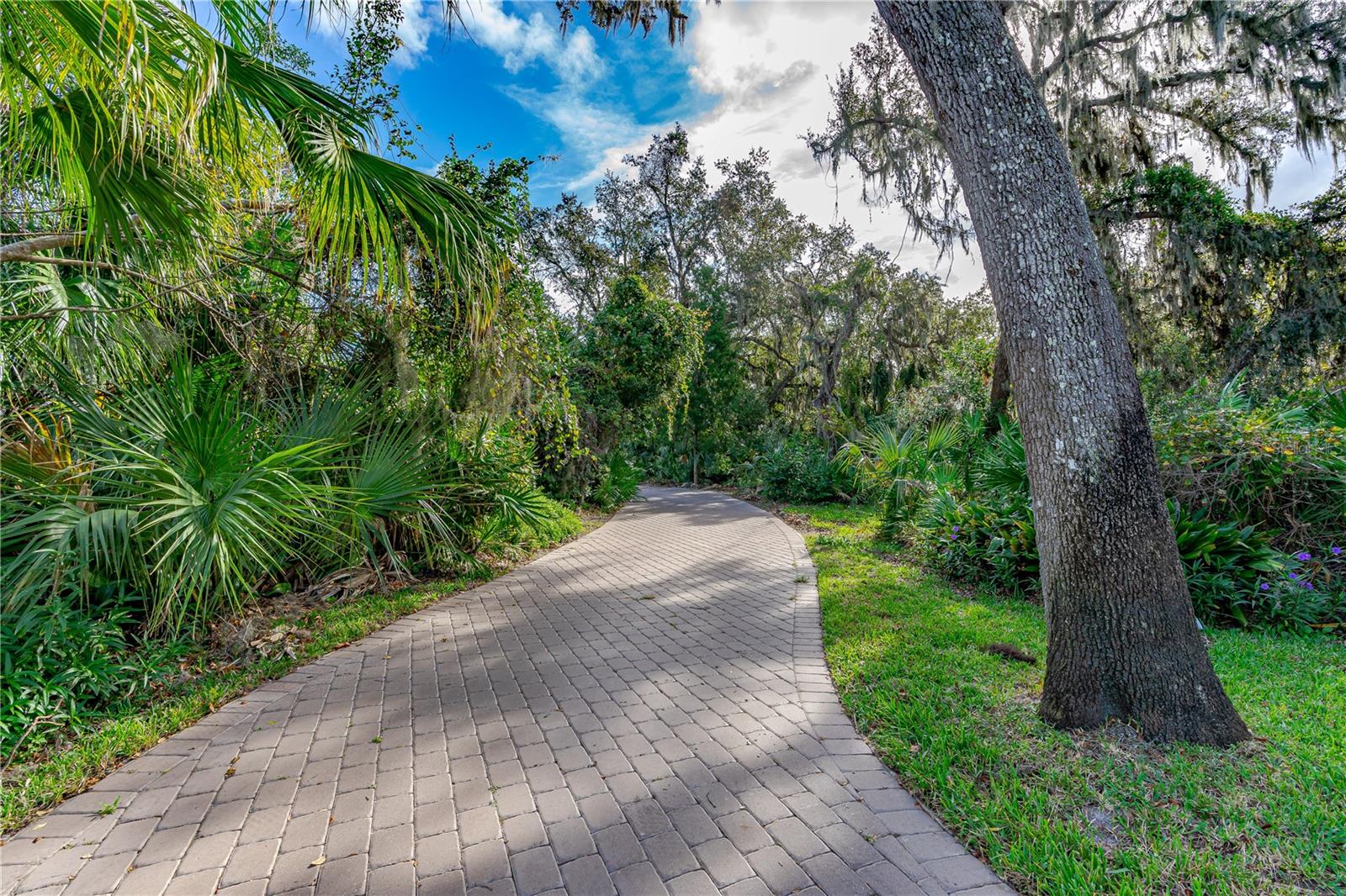 Private 1 Acre Brick Home in Spruce Creek Estates. Enjoy privacy and comfort in this spacious split-plan home featuring a double wood-burning fireplace, open living area, and a formal dining room perfect for entertaining. The chef's kitchen offers GE Café appliances, double oven, microwave drawer, center island, floating shelves, and a large pantry. The primary suite is a peaceful retreat with walk-in plus double closet and updated bath with double vanity and large shower. Guest suites are privately located on the opposite side. A versatile Florida Room is ideal as a gym, game room, or extra living space. Outdoors, relax by the saltwater pool, rinse off in the outdoor shower, or enjoy the cozy front porch. Updates include paver driveway/walkway, roof (2017), AC (2020), water heater (~2019), and garage door (2019). No flooding during recent hurricanes. Convenient to shopping, dining, and the beach, with plenty of room for recreational toys.