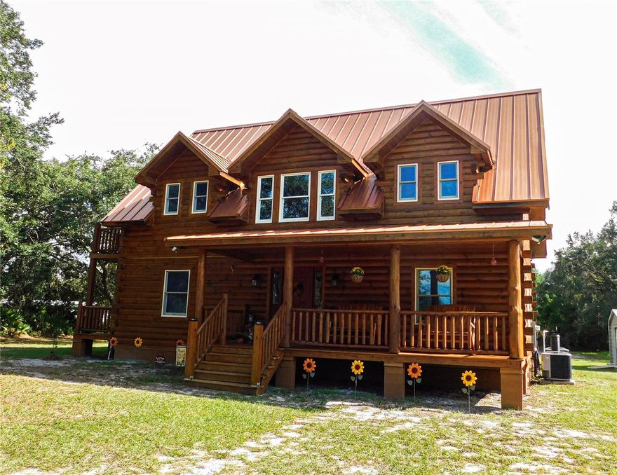 This home is back on the market due to buyer financing falling through, don't miss this second chance!
Step into this unique, once in a lifetime listing! A fully finished, rustic chic, two-story luxury log cabin nestled in the heart of central Florida. Living here is like being at your dream rustic getaway all the time.
This three bed, four bath two-story home was custom built in 2019 by a log home constructor from North Carolina, making it not only totally one of a kind but also fitted with new, high quality fixtures throughout. There is also an unfinished attic that offers storage space with potential to be converted into a loft space. Situated on five acres of land with an enclosed three and a half acre pasture in the back, this property is perfect for a family ready to start or expand their homestead. 
Enter the five acre property from either of its two driveways and immediately see the beautifully stained log home with a striking copper roof. Upon entering the home, you can smell the wood and see the beautiful natural markings of the logs bathed in the warm lighting from the custom copper light fixtures throughout the house. The first floor is an open floor-plan with a large living room space, spacious kitchen with brand new appliances and gorgeous quartz counter tops, a laundry/mud room with a back door entrance, a downstairs full bathroom, and a dining room with a beautiful and unique chandelier. The kitchen has wood cabinets with under the cabinet lighting as well as statement lighting fixtures above the copper farm-style sink where you can look out the large window to see the back of the property. The luxury vinyl flooring throughout the house ties everything together. The stained wood stairs take you to the next level which has a custom design on the midway landing. The second story has three bedrooms, the primary, and two generously sized additional rooms. All three bedrooms have their own attached bathroom. The primary bedroom’s bathroom offers a jacuzzi tub with beautiful stone tiling as well as a custom built shower. There is also a balcony attached to the primary bedroom, the perfect place to enjoy the natural Florida wilderness you’re surrounded by. The primary bedroom has a large walk-in-closet with barn doors as well. The house offers excellent natural lighting with Anderson hurricane proof windows and doors. 
The property has dual AC units, for the upstairs and downstairs. A detached garage behind the home offers extra storage. The property is equipped to have water and electric run to the back of the five acres for farming as well. This secluded five acre lot offers privacy and serenity surrounded by Florida’s natural environment as it backs up to the Lake Wales Ridge State Forrest, which is thousands of acres of protected land. At the end of Wakeford Rd., just a half a mile walk from this property, is the Tiger Creek Preserve which offers multiple beautiful walking trails. While this property offers a degree of seclusion from the hustle and bustle of a town or city, it is still a less than fifteen minute drive into the main hub of the quaint and growing town of Lake Wales.