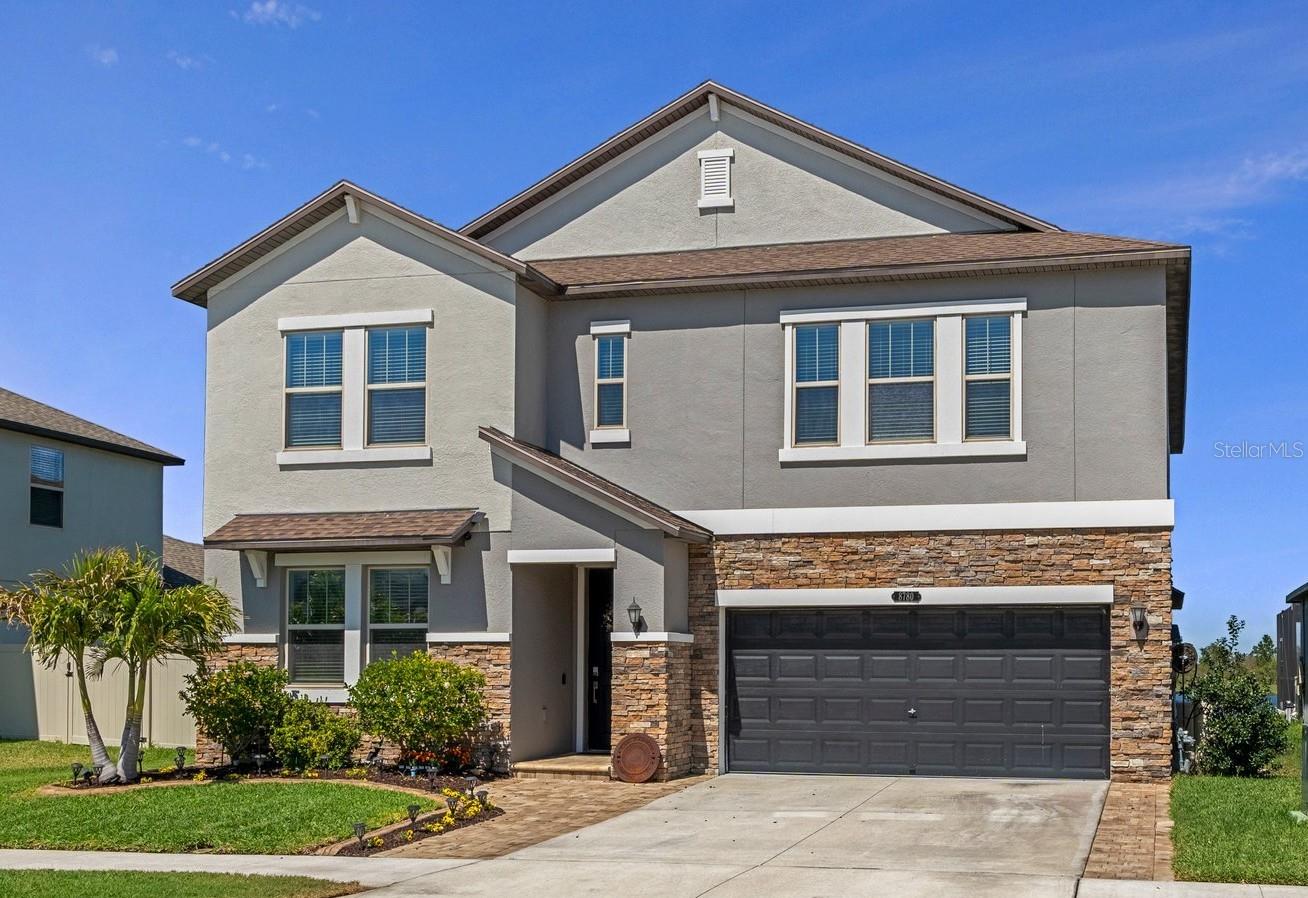 PRICED TO SELL! Best Value in Connerton. This stunning 5-bedroom, 4-bath home with a 3-car tandem garage is located in the highly desirable Connerton community and offers upgrades that outshine NEW CONSTRUCTION. The open-concept gourmet kitchen, dining area, and family room create a flexible space perfect for any lifestyle. The thoughtfully designed kitchen features 42" cabinets, granite countertops with island bar seating, stainless steel appliances, a gas range, a butler's pantry, a walk-in pantry, recessed lighting, and a casual dining area ideal for gatherings. The owner's retreat provides a tranquil escape with a spacious walk-in custom closet, dual sinks, a soaking tub, and a separate walk-in shower. Step outside to your private oasis with a gorgeous in-ground pool complete with a sun shelf, bubbler, and built-in volleyball inserts. ENJOY SERENE LAKE VIEWS FROM THE EXTENDED PAVER PATIO WHILE SIPPING YOUR MORNING COFFEE OR EVENING COCKTAIL. Additional features include a first-floor half bath, a drop-off zone, and both first and second-floor laundry facilities, with the option to use one as extra storage. Upstairs, a generous loft area serves as a perfect theater room, game room, study, or library, along with four large bedrooms and two full baths, each with dual vanities. Special highlights include a tankless water heater, reclaimed water irrigation system, ceiling fans, a Wi-Fi-enabled garage opener, video doorbell, and window blinds. The original owners have added custom lighting, a whole-house Culligan water softener with a reverse osmosis faucet in the kitchen, a paver driveway extension, and a welcoming front path. The garage is equipped with an EV outlet and generator transfer switch, making this home plug-in ready. Residents enjoy an unmatched lifestyle with access to a 10,000 sq ft clubhouse and more.