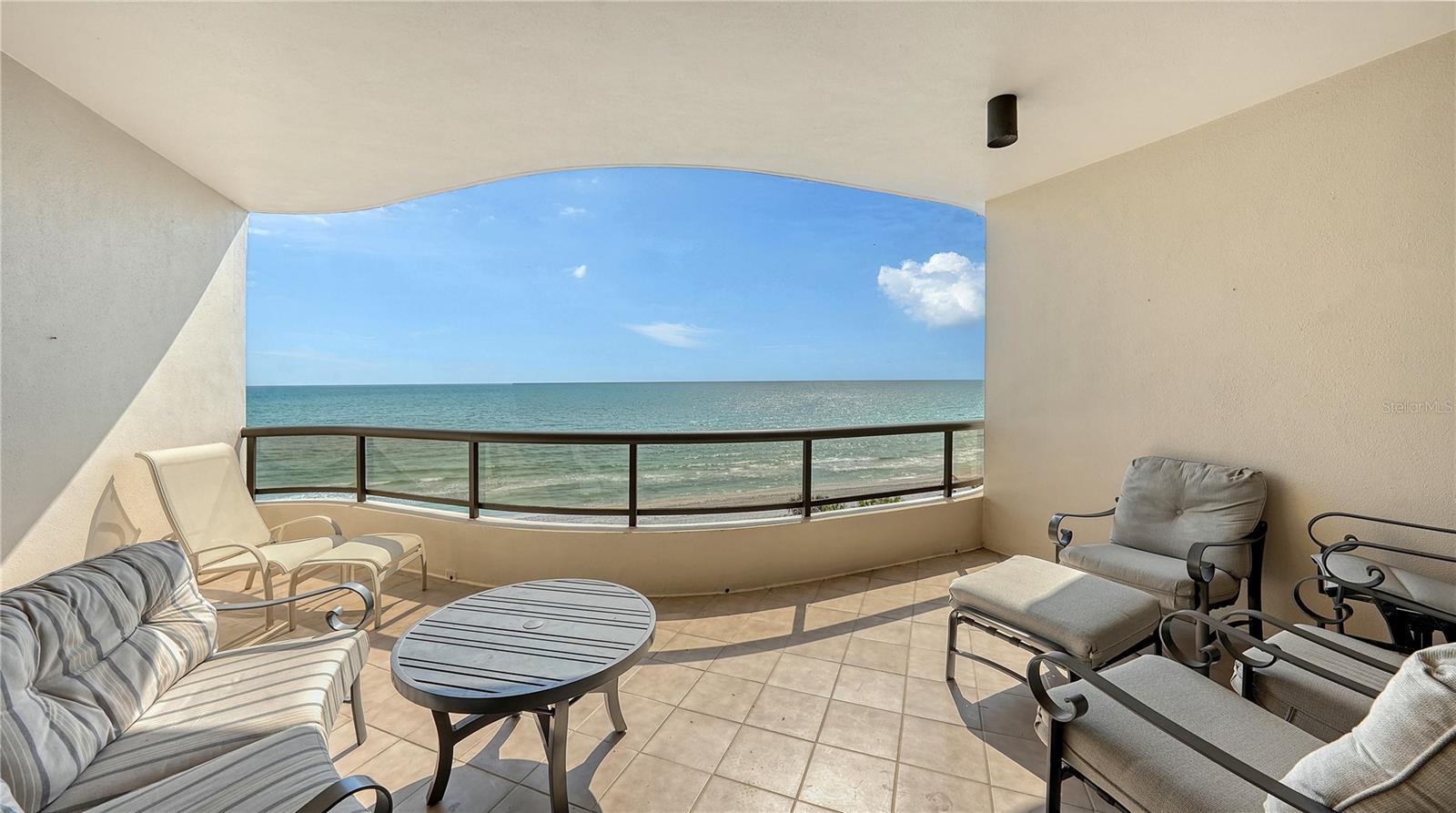One or more photo(s) has been virtually staged. Sweeping Gulf, bay, and spectacular city skyline views set the stage for this elegant fifth-floor retreat at L’Ambiance, one of Longboat Key’s most esteemed beachfront communities. Poised along the pristine shoreline and offering nearly 3,000 square feet of refined interiors, this residence delivers both sunrise and sunset splendor from two expansive terraces. Beyond the private elevator foyer, a beautifully updated interior unfolds—anchored by wide-plank wood flooring laid in a subtle diagonal pattern and framed by custom built-ins in a warm wood tone. Natural light pours in through walls of new, state-of-the-art impact glass sliders and oversized windows, casting a gentle glow throughout the entire residence. The open living and dining areas enhance the layout’s effortless flow. The chef’s kitchen is both stylish and functional, featuring quartz countertops, sleek neutral cabinetry, stainless steel appliances, a center island, and artistic tile backsplash. A cozy breakfast nook and nearby den (easily convertible into a third bedroom) create a versatile layout ideal for both entertaining and everyday living. The split-bedroom plan provides privacy and comfort. The primary suite is a tranquil escape with stunning direct Gulf views, terrace access, multiple closets, and a spa-inspired marble bath with dual vanities, soaking tub, and separate water closet. On the opposite end, the guest suite enjoys its own terrace with exquisite views of the bay and downtown, along with a full en-suite bath. Additional features include 10-foot ceilings with detailed crown molding, convenient laundry room that also acts as a Butler’s pantry with wine cooler, two secure garage parking spaces, private storage, and individual wine locker. L’Ambiance residents enjoy a host of exclusive amenities: 24-hour security, superb concierge services, updated social and fitness centers, tennis courts, and a Gulf-front heated pool and spa—all set behind the gates of the prestigious Longboat Key Club. A private boardwalk leads directly to the powdery sands of the Gulf, while nearby attractions elevate the lifestyle even further. Explore world-class golf and marina amenities, dine at acclaimed restaurants, and spend your afternoons shopping at St. Armands Circle or browsing downtown Sarasota’s galleries and theaters just over the bridge. L’Ambiance is where refined luxury meets beachfront ease—an exceptional opportunity to experience coastal living at its finest.