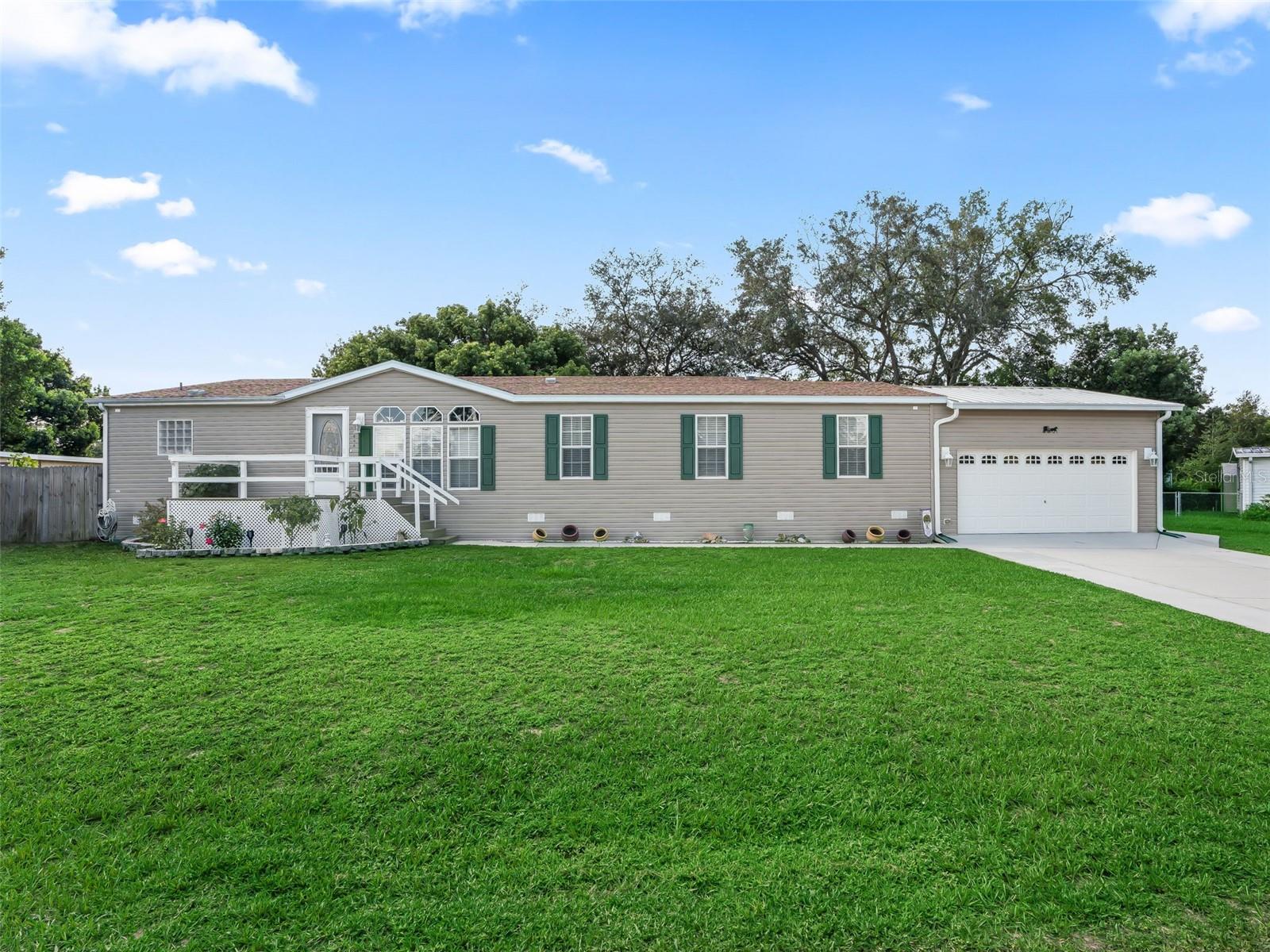 Spacious 4 Bedroom / 2 Bathroom Triple-Wide Manufactured Home with 2,359 sq. ft. of heated and cooled living space, located in the desirable Mobile Homes Meadows community. This home features laminate flooring in the owner’s suite and main living areas, tile in the kitchen and baths, and carpet in the guest bedrooms. The kitchen offers ample countertop space, a large island, and a dinette, making it the heart of the home. Additional highlights include an inside laundry room with storage cabinets, a beautiful paver courtyard—perfect for cookouts and entertaining, and a 20' x 34' attached garage (added in 2017). Major updates include a new roof (2021)and new water heater (Aug. 2025). The property also features a well with its own shed and an extra outbuilding ideal for toys, lawn, and landscape equipment. Furniture / Turnkey package available separately. Conveniently located just minutes from shopping, medical facilities, and restaurants, and close to The Villages for nightly entertainment and more. Room Measurements and Square Footage are approximate and should be verified by buyer/buyer’s agent. Don’t wait—schedule your private showing today!