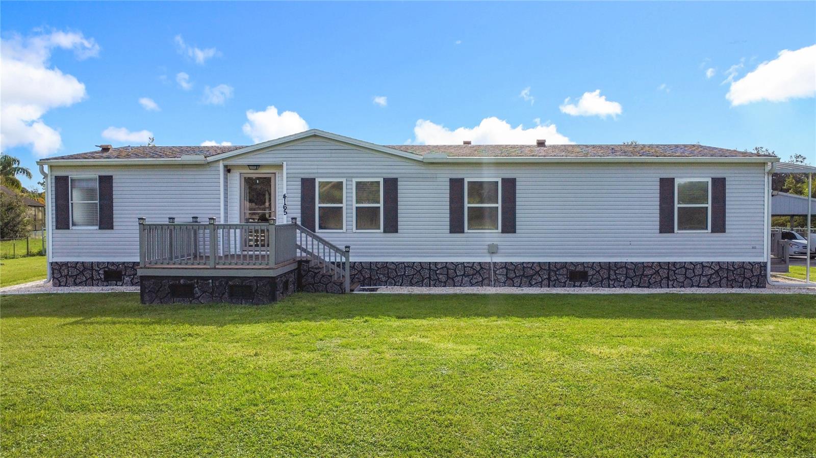 Country-style living without going to the country on 2.41 acres where live stocks, horses RV and your big toys are welcomed. Newly renovated bathrooms with granite countertops. Roof replaced in 2019. This fenced 3 bed 2 bath home features open floor plan with split bedrooms for privacy. Enclosed screen in patio. Front porch for cool evenings. You don't have to worry about HOA because there is none. With this much land, you can build or add an ADU, Accessory Dwelling Unit, which simple means another home. Minutes away from Florida's Turnpike. 45 Minutes from the Atlantic heading East on 192. Paved driveway all the way up to the home with remote security. You have got to see this home as it won't last. The owners did some amazing upgrades in this home.