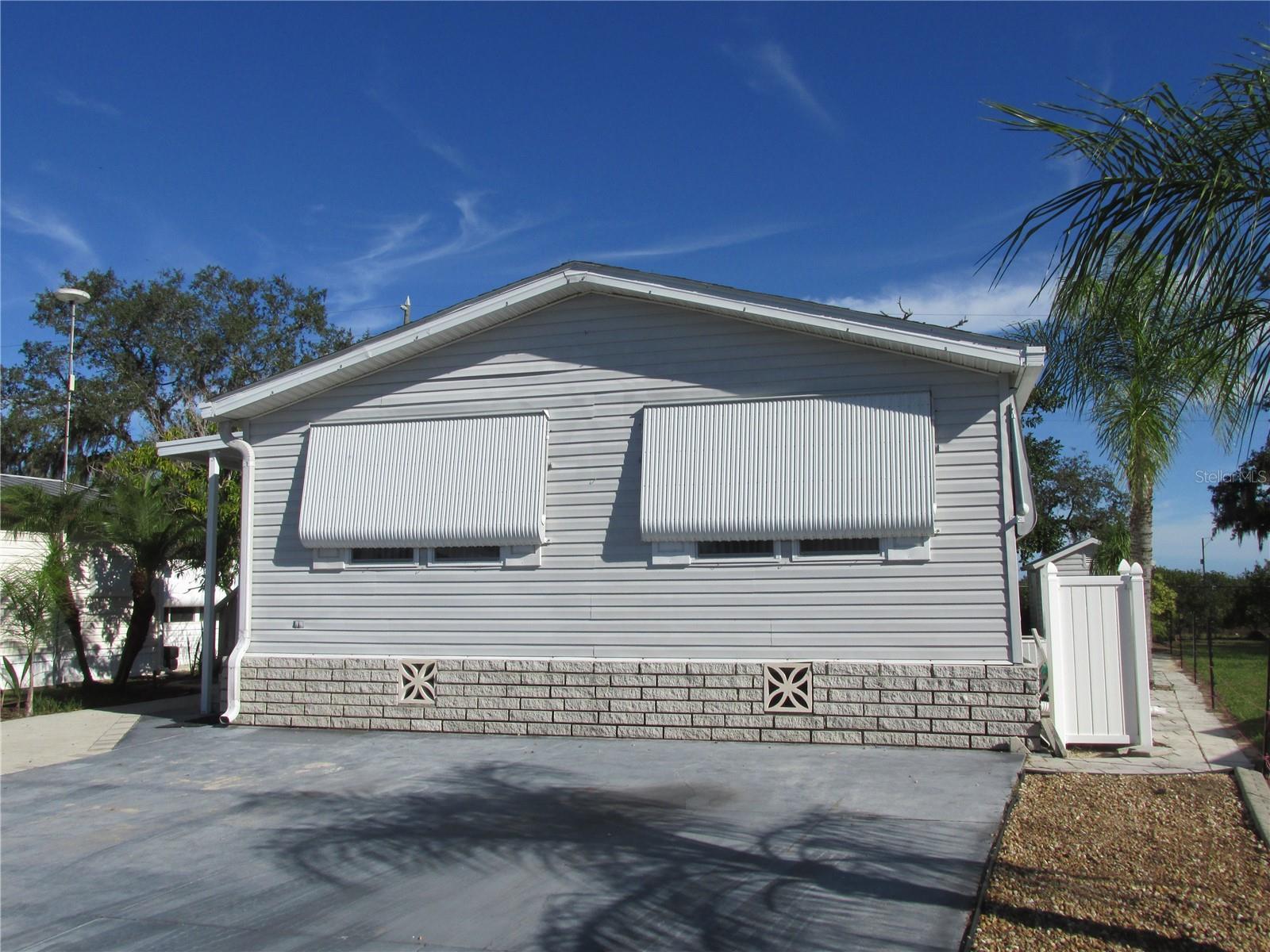 Located in the premier 55+ gated community of Saddlebag Lake Resort, where you OWN the land, this 2/2 Jaco double wide manufactured home comes fully furnished.  You'll need to replace most of the flooring, but the list price reflects this. The kitchen has a new Samsung bottom freezer refrigerator, plus a dishwasher, double sinks with disposal, microwave and glass top stove.  You will love the generous amount of counter space, not to mention the two-sided overhead cabinets with decorative glass doors, which matches the built-in china cabinet in the dining room. The owners suite has an ensuite bathroom with shower stall, and your guests will enjoy their own bedroom with separate guest bathroom.  There is a very large bonus room at the back of the home that is perfect for use as an office, craft room, or multi-purpose room, complete with a storage closet.  Step through the sliding door into an expansive Florida room, the perfect place for entertaining friends and family.  Equally as impressive as the inside of this spacious home is the outside, with it's wide wraparound patio, complete with a golf cart port, and lush tropical landscaping, with palm trees and ferns, including a beautiful staghorn.  There's even a workshop with power where you can work on projects and store your tools.  The home backs up to an orange grove, so you'll have no rear neighbors.  The low quarterly HOA fee covers your water, sewer, trash pickup and use of all the amenities.  There's a clubhouse where you can participate in planned activities and get to know your neighbors, a crystal clear heated community pool, a screen-enclosed hot tub, a rec room with saunas and pool tables, a fitness center, tennis, pickle ball and shuffleboard courts, horse shoe pits, a driving range, a community boat ramp so you can access Saddlebag Lake for boating and fishing, and a beach house with kitchen and covered patio that you can use at no cost, just reserve it.  The resort is pet friendly, and there's a dog park at the back.  You won't even have to leave to get your mail, there's a post office onsite.  With so much to offer, this home won't last long so call now to schedule your private tour!