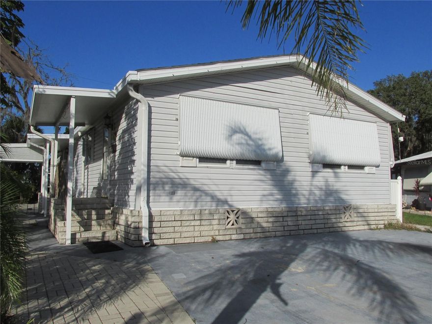 Located in the premier 55+ gated community of Saddlebag Lake Resort, where you OWN the land, this 2/2 Jaco double wide manufactured home comes fully furnished.  You'll need to replace most of the flooring, but the list price reflects this. The kitchen has a new Samsung bottom freezer refrigerator, plus a dishwasher, double sinks with disposal, microwave and glass top stove.  You will love the generous amount of counter space, not to mention the two-sided overhead cabinets with decorative glass doors, which matches the built-in china cabinet in the dining room. The owners suite has an ensuite bathroom with shower stall, and your guests will enjoy their own bedroom with separate guest bathroom.  There is a very large bonus room at the back of the home that is perfect for use as an office, craft room, or multi-purpose room, complete with a storage closet.  Step through the sliding door into an expansive Florida room, the perfect place for entertaining friends and family.  Equally as impressive as the inside of this spacious home is the outside, with it's wide wraparound patio, complete with a golf cart port, and lush tropical landscaping, with palm trees and ferns, including a beautiful staghorn.  There's even a workshop with power where you can work on projects and store your tools.  The home backs up to an orange grove, so you'll have no rear neighbors.  The low quarterly HOA fee covers your water, sewer, trash pickup and use of all the amenities.  There's a clubhouse where you can participate in planned activities and get to know your neighbors, a crystal clear heated community pool, a screen-enclosed hot tub, a rec room with saunas and pool tables, a fitness center, tennis, pickle ball and shuffleboard courts, horse shoe pits, a driving range, a community boat ramp so you can access Saddlebag Lake for boating and fishing, and a beach house with kitchen and covered patio that you can use at no cost, just reserve it.  The resort is pet friendly, and there's a dog park at the back.  You won't even have to leave to get your mail, there's a post office onsite.  With so much to offer, this home won't last long so call now to schedule your private tour!