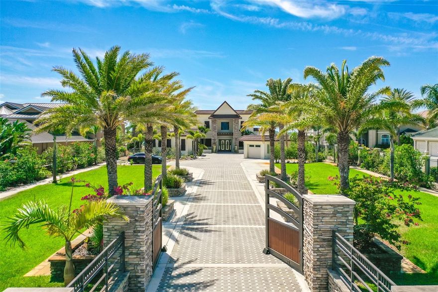 Introducing a stunning gated beachside riverfront estate, set on an expansive 1.4 acres that evoke a park-like atmosphere, located just minutes from the beautiful shores of Daytona Beach. This custom-built luxury home boasts an impressive 4,985 square feet of living space, featuring three spacious bedrooms, three full bathrooms, and two half baths, along with an in-law suite, an office, and a versatile loft that's perfect for family life and entertaining. Additionally, the property includes a generous four-car garage totaling 1,152 square feet. With 115 feet of waterfront access, complete with a deep-water dock, this estate offers an exceptional blend of comfort and outdoor enjoyment.

Showcasing over a million dollars in high-end upgrades. As you pass through the elegant gates, you’ll be welcomed by a sprawling paver motor court with custom stacked stones pillars. This home boasts a robust concrete block stucco exterior with striking stacked stone pillars all leading to a grand and inviting entrance. Upon entering through the double doors, you’re immediately met with a soaring 22-foot ceiling that frames expansive river views, while an exquisite crystal chandelier hangs seamlessly with understated elegance. The first floor is finished with lustrous 36x36 porcelain tiles, adding a touch of modern refinement.

Step into the chef inspired kitchen adorned with a contemporary flair highlighted with black wood cabinets, an impressive custom island, soft close drawers, and wrapped in a double slab stone countertop. Kitchen Aid appliances with two refrigerators, two dishwashers, double oven, warming drawer, and 6-burner gas stove with pot filler. The butler's pantry is tucked away for seamless hosting, equipped with a dishwasher, deep sink with disposal, and large pantry. Right off the kitchen is the spacious living room which features travertine stacked stones all the way up the wall to create a beautiful feature wall with a contemporary fireplace and tv niche. 

Ascend the custom-built walnut staircase, adorned with wrought iron balusters, to discover the upper level encompassing 1,283 square feet of exquisite living space. The primary bedroom offers breathtaking river views, complete with a private deck that overlooks the pool. The primary bath exudes luxury, featuring a relaxing soaking tub, a walk-in shower with striking tile that elegantly extends up the wall, a separate toilet and bidet in the water closet, and a spacious walk-in closet. Additionally, the upper level includes a stunning loft.

Downstairs, you'll find a riverfront bedroom that features a cozy in-law suite, complete with a private living room and a well-appointed laundry room, equipped with ample cabinetry and two washing machines and dryers for added convenience. The full bathroom showcases rustic charm, featuring a thoughtful mix of gray, brown, and beige tiles that evoke a farmhouse aesthetic. Additionally, the third bedroom comes with its own ensuite bathroom.

The inviting backyard is highlighted by a lovely pool, added in 2017, which is perfect for relaxation or entertaining guests, a large pergola, and walkways in a serene setting. The 2019 sea wall provides added protection and stability, enhancing the property’s value and appeal. For those who enjoy boating, this property is an entertainer's dream. Square footage received from tax rolls. All information intended to be accurate but cannot be guaranteed.