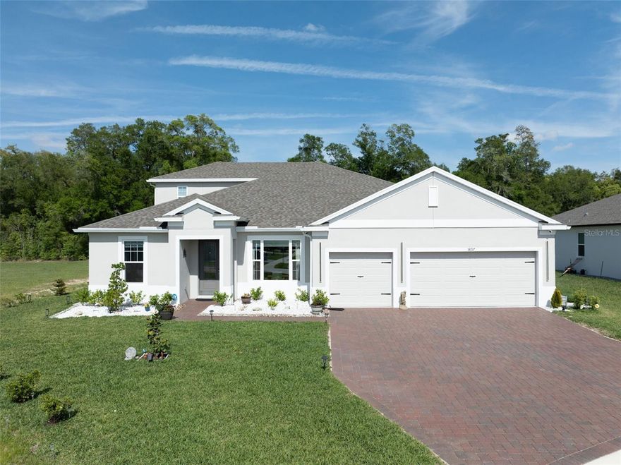 Located on a PREMIUM CORNER LOT, this 2025-built luxury home with a screened-in heated saltwater pool delivers the perfect blend of modern design, privacy, and high-end upgrades. With NO REAR OR LEFT SIDE NEIGHBORS and backing to a wooded conservation area, this property offers rare seclusion in a highly desirable setting. This stunning 5-bedroom, 4-bath home with a dedicated office/den and 3-car garage features a bright, open-concept layout with 10' ceilings, 8' doors, tray ceilings, wood-look tile flooring, 5 1/4" baseboards, and designer finishes throughout. Step inside to a formal dining area and a private office with French doors providing both elegance and functionality. The split floor plan enhances privacy, highlighted by a first-floor primary suite with direct access to the pool and patio, creating seamless indoor-outdoor living. The suite features a garden tub, an oversized walk-in shower, dual vanities, and a large custom closet. Upstairs, a private retreat includes a spacious bedroom and full bath, ideal for guests or multigenerational living.The chef's kitchen is built to impress, featuring a massive quartz waterfall island, built-in double ovens, a gas cooktop, premium stainless steel appliances, ceiling-height white cabinetry, and a walk-in pantry, designed for both everyday living and entertaining. A convenient pool bath with double sinks and an upgraded shower door offers direct backyard access. Step outside to your own private resort-style backyard on an oversized .36-acre lot, featuring a new screened-in heated saltwater pool, a sealed paver deck, ambient pool and outdoor lighting, lush landscaping, and recently planted Italian cypress trees that enhance both privacy and luxury appeal. The 3-car garage offers epoxy flooring, built-in storage, and an upgraded LiftMaster garage door, blending style with functionality. Additional upgrades include a water softener system, gutters, custom blinds, upgraded light fixtures, a shed, a pool privacy screen, a pest control system, security system and much more. With a minimal HOA, this home delivers the perfect balance of privacy, luxury, and location! Just 5 miles from Downtown Mount Dora and about 30 minutes to Orlando. A rare offering featuring a premium lot, new construction, a resort-style pool, and luxury upgrades throughout, truly move-in ready. POOL AND PATIO FURNITURE INCLUDED WITH FULL PRICE OFFER.