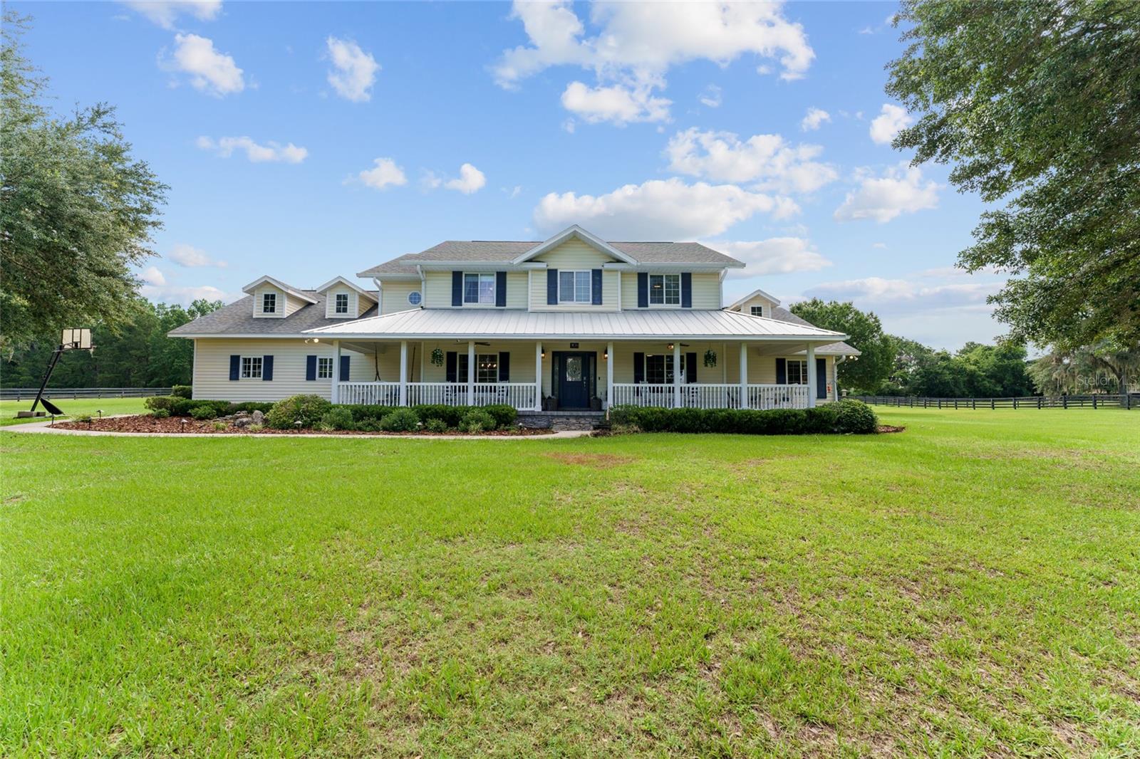 Seller agrees to contribute up to $10,000 toward Buyer’s closing costs and prepaids, subject to acceptance of a reasonable offer. Hold on to your saddles, because this one is truly special! Nestled in the heart of South Ocala’s renowned horse country, this move-in ready equestrian estate in the exclusive community of Bridle Run offers a rare blend of luxury, functionality, and serene rural living. Situated on 4.36 acres with access to private, non-motorized community bridle trails, this property is ideal for equestrian enthusiasts, nature lovers, or anyone seeking refined country living. An automated gated entrance welcomes you to this beautifully maintained 5-bedroom, 3-bathroom POOL home featuring an upstairs theatre room with a mini kitchen and additional attic space—perfect for a media room, home office, or guest suite. Thoughtful upgrades include solar power with a grid-tie system (unused energy is sold back to the grid), electric vehicle/generator-ready garage, fiber optic internet, and a newer water heater and heat pump. The home includes two AC units—one replaced in 2021 and the other original but functioning well with recent service. The interiors feature built-in carpet in the living room and stairs, with propane lines already in place for the saltwater pool, and both indoor and outdoor gas fireplaces. The washer and dryer units (two-in-one models) will stay with the home, and the property is equipped with well and septic systems for added independence and efficiency. Outdoor living is a dream with a resort-style pool area complete with a kitchen and grill setup, a charming pergola, fire pit, generator ready, and a tranquil river waterfall. A detached garage includes a workshop and attic storage, perfect for hobbies or additional space. The grounds also feature a garden, sandbox, and plenty of open space for both your family and horses to enjoy. Bridle Run’s HOA maintains the main entrance and trail system, with a scenic horse trail running directly behind the home. A new school is being built nearby, adding value and convenience to this already desirable location. Enjoy being less than 10 minutes from the Florida Horse Park and Marjorie Harris Carr Cross Florida Greenway Trails, approximately 15 minutes from Downtown Ocala, and only 25 minutes from the World Equestrian Center. Whether you’re living the equestrian lifestyle or simply looking for peaceful country luxury, this exceptional Bridle Run property is not to be missed.