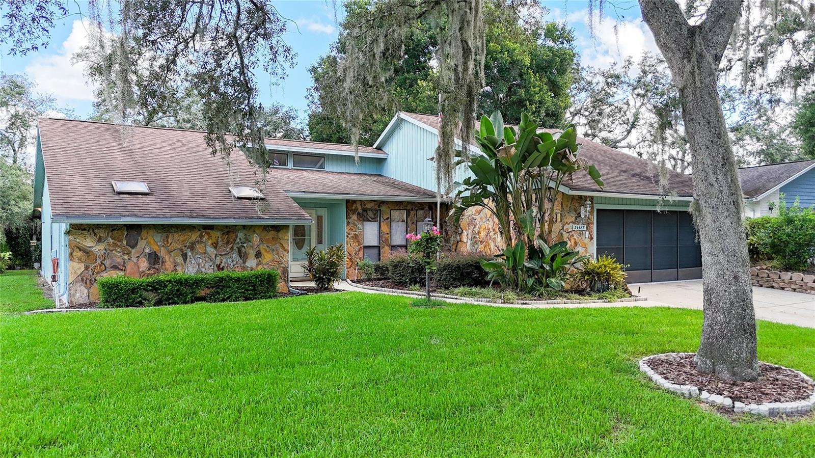 SOME PHOTOS HAVE BEEN VIRTUALLY STAGED. A TRUE FLORIDA LIFESTYLE AWAITS YOU HERE! This beautifully manicured 3/2/2 home trimmed with Zyrian stone is nestled in the trees and overlooks a scenic natural preserve. The great room with formal dining greets you with engineered wood flooring and volume ceilings - talk about a WOW effect! Custom French doors lead into the oversized Florida room which is a perfect place to enjoy the Super Bowl and so many other fun activities. The deluxe eat-in kitchen if fully applianced and is complete with solid surface counters and custom cabinets. It is open to the great room so the chef in the kitchen will never need to feel isolated. The inside laundry room is ready to use with the washer and dryer included. The bedrooms are split which is great for privacy. The spacious primary suite has an oversized walk-in closet and a luxurious bath with a walk-in shower plus garden tub. When you leave the Florida room, you'll enter an oversized screened lanai with vinyl enclosures which allow for year 'round enjoyment. Next you'll discover the inviting, caged in-ground pool! How much better can it get? The Whispering Oaks Estates community is a Master planned community with private roads, a recreation center and a super affordable HOA - this year, the annual dues are just $264 - that's ANNUAL not MONTHLY! If you want to enjoy convenience, the location is super central to so many places - I-75, Florida's famous gulf coast beaches, Tampa and Orlando and all of their attractions and amenities, Ocala, the charming downtowns of Dade City and Brooksville and so much more. The Rails to Trails hiking trails are nearby as well as the winding Withlacoochee River. Come see for yourself! YOURS for $415,000!