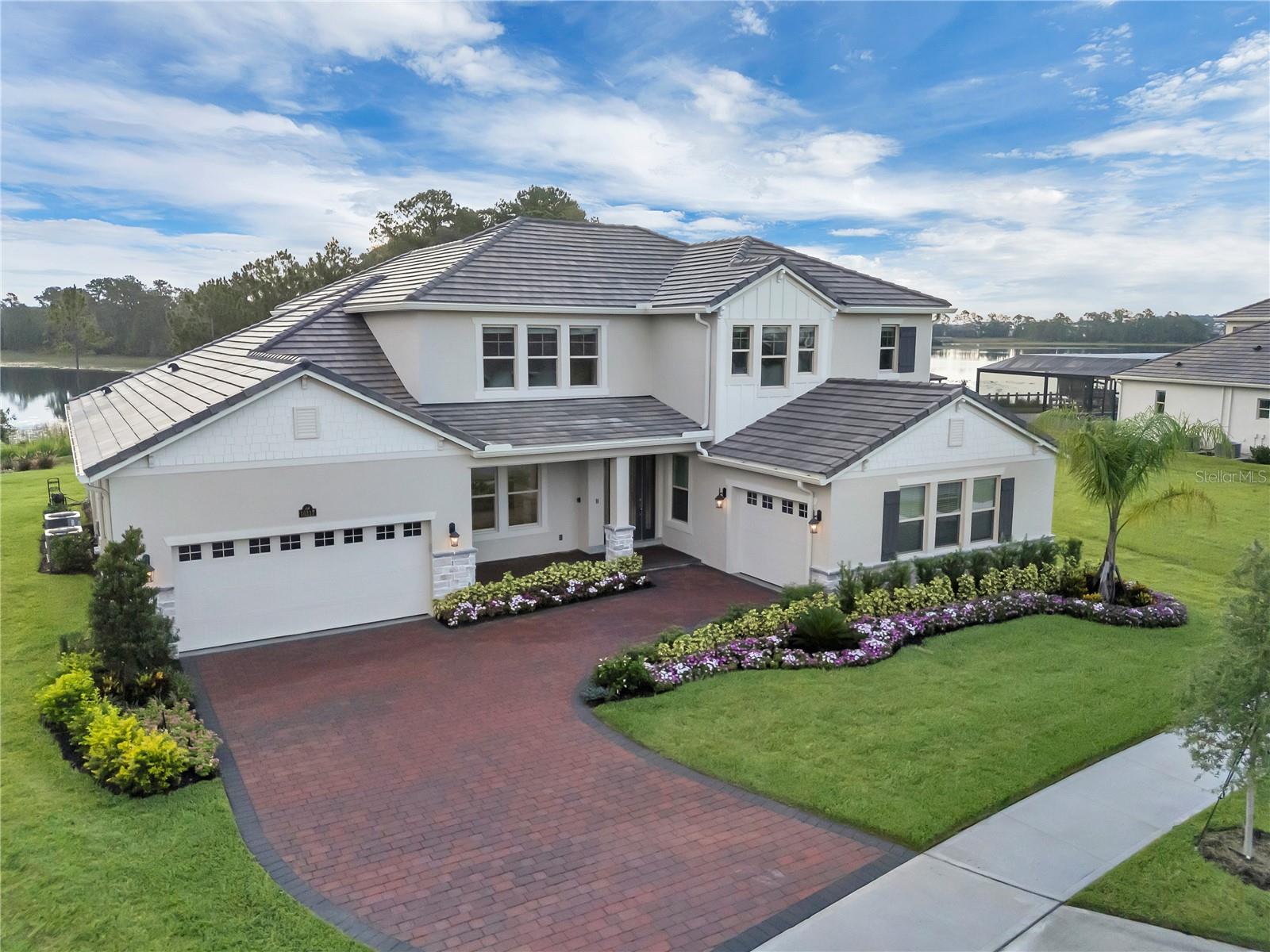 *NEW HOUSE* Welcome to Casa Copacabana — a custom waterfront villa unlike any other in Waterleigh
This New, fully customized masterpiece 2 STORY CONCRETE BLOCK ON THE BEST LOT ON LAKE HICKORYNUT redefines luxury in the heart of Winter Garden’s prestigious Waterleigh community. As the last new lakefront home in the Emerald Collection (only 17 were ever built), Casa Copacabana stands alone — not only as the largest lakefront lot in the community, but also as the one with the most breathtaking panoramic views. From sunrise over the water to nightly Disney fireworks over the lake, this home offers a daily spectacle of Florida living at its finest.
Completely reimagined from builder-grade to custom luxury, this home is anything but cookie-cutter. Over 140 square feet of added lake-view windows, a 12-foot pocketing slider, and upgraded architectural elements elevate this into a one-of-a-kind showpiece. The heart of the home — the chef’s kitchen and adjoining wet bar — stuns with European-inspired matte gray and matte gold cabinetry, a nearly 12-foot soft Blue Quartzite waterfall island, and top-of-the-line, powered by AI, Samsung Bespoke appliances.
Step inside, and the grandeur unfolds: a stunning 12' x 8' sliding glass wall opens to an unobstructed view of the widest point of Lake Hickorynut, framed by a pristine pine-lined peninsula. Every surface has been carefully curated, from Valencia white Spanish porcelain tiles with gold and gray veining, to Tennessee hickory hardwood flooring, which continues into the primary suite, second floor, and even onto a statement ceiling in the formal dining room.
The primary bath is a true spa sanctuary: a custom wet room with dual six-function rainfall shower panels, a picture window over a freestanding tub, and a stunning ceiling-mounted Kohler Purist tub filler. Over 100 cubic feet of exotic teal blue European cabinetry elevate the space into a private retreat. Each of the home’s three redesigned bathrooms offers elevated finishes and thoughtful design.
Custom wood closets throughout (no wire shelving here), built-in cabinetry in the laundry room, media room, and upstairs family room, and full-home high-speed data wiring deliver seamless function to match the form.
Outside, explore Lake Hickory Nut, a private paradise ideal for boating, paddleboarding, fishing, or taking advantage of the lake’s professionally surveyed water ski slalom course. Nearby shopping at Flamingo Crossings and Hamlin, and close proximity to Disney, downtown Winter Garden, Windermere, and Orlando’s renowned attractions, put the best of Central Florida at your doorstep.
Casa Copacabana isn’t just a home—it’s a statement. A lifestyle. A lakeside dream brought to life. Just a few miles from Disney World.