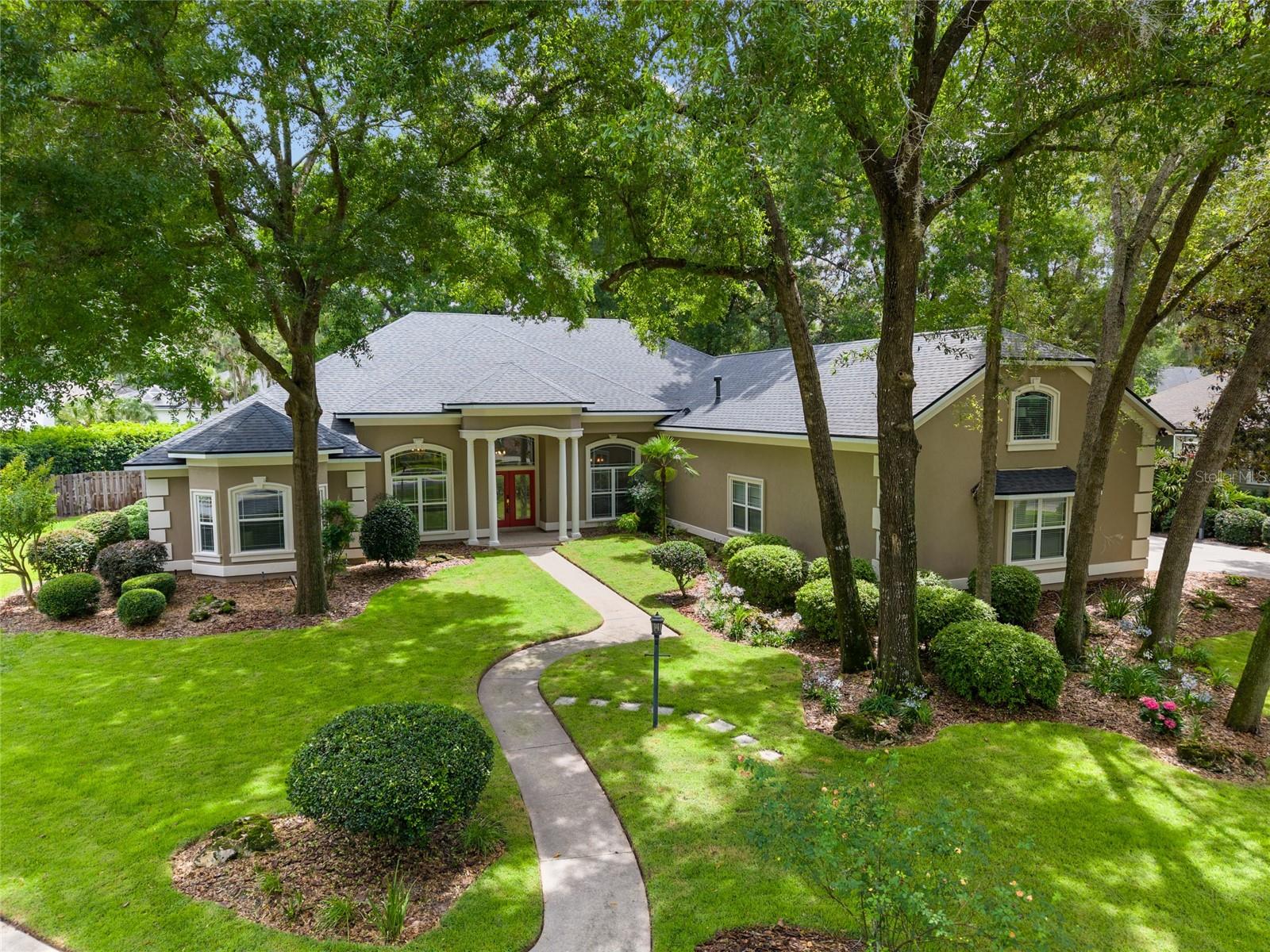 This turn-key home has the space you need, a superior lot, and a private backyard that will have you looking forward to the summer weekends for splash and play. This GW Robinson built home features one of the most popular plans GW offered with custom homes – 5 bedrooms downstairs with a 3-way split plan, plus a 6th bedroom/flex room/bonus room with full bathroom upstairs. With just over 4100 SF, the ease of comfort of this home is felt the moment you step inside. Located on a corner lot, this home has 3 sides with no neighbors. This .56-acre professionally landscaped lot affords a very private pool and lanai area, and backyard. Mechanical UPDATES: 2022 roof, sprinkler system, recent pool refinishing, newer pool heater, new pool control panel system, newer water heater, 2022 zoned HVAC, and a new summer kitchen. Interior UPDATES: NEW master bathroom renovated by Pridgen Home Services, professionally painted kitchen cabinetry, newer refrigerator and DW, modern family room, sitting room and master bedroom lighting, built-in bay window seating, and updated luxury vinyl plank flooring in all rooms including the bedrooms. Once inside, you will immediately notice the 12-foot ceilings. The separate formal dining room, with triple step-up tray ceiling, is on your right; to your left is the former living room. Use this space as a sep. sitting area, playroom or reading room. The family room has a gas fireplace as its focal point with extensive built-ins flanking each side; and 2 French doors that lead out to the lanai and pool area. The Chef’s kitchen has an expansive breakfast bar, solid surface counters, island with exotic granite, corner pantry, newly painted neutral wood cabinets, and a SS appliance package including double ovens and gas cooktop. A spacious breakfast room overlooks the pool area. Two guest rooms are off the right corner of the family room, which can be closed off via pocket door. The hallway bath serves as the pool bath, with a separate hallway French door to the lanai. The 2nd guest wing is on the opposite corner of the family room, also with a pocket door for privacy. The front bedroom with bay window, currently used as a home office, has a new built-in window seat. The hallway bath is situated between the guest rooms. The master wing is located on the right side of the home. Its en suite spa-like bath is newly renovated, and includes 2 expansive vanity areas with dressing table, large shower, garden tub and private water closet. Between the bedroom and bath are his-and-hers walk-in closets. The master bedroom features one of GW’s popular details – a smaller sep. room with double pocket doors for privacy. This would be an ideal nursery, secondary home office or gym. Spanning the width of the 3-car garage below is the upstairs bonus room/flex room or 6th bedroom complete with full bath. Access the screened lanai and pool/spa area via the guest wing French door, family room or master bedroom. With two covered seating areas, enjoy lounging by the pool and spa, or dining near the new summer kitchen. Worried about fun and play space? No need with this lot – the fully fenced yard is perfect for running about or free-play, completely landscaped with tall hedges for privacy. Additional features include an interior laundry room with cabinetry for storage, and a 3-car side entry garage. Cobblefield features a community pool, playground, street lights, and sidewalks, located near both private and public schools, shopping, and Publix.