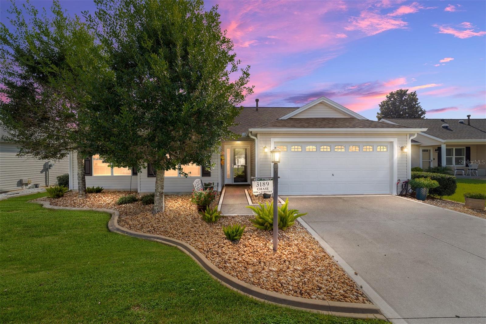 This beautifully maintained Whispering Pines model with NO BOND offers three bedrooms, two baths, and a two-car garage, perfectly situated in the desirable Village of Polo Ridge. The light-filled open floor plan features vaulted ceilings and solar tubes that fill the home with natural light. The kitchen is equipped with quartz countertops, under-cabinet lighting, and stainless steel appliances that are only three years old. An electric fireplace serves as a focal point in the living area, and French doors lead to the enclosed lanai, creating a seamless transition between indoor and outdoor living spaces. The owner’s suite includes a shower with a built-in bench, dual sinks, and ample closet space, while the split bedroom design ensures privacy for guests.
Outside, the private backyard is enhanced by mature landscaping, offering a peaceful retreat. Recent updates include a newer roof, newer HVAC, and a newer water heater, providing added peace of mind. An irrigation system and low-maintenance yard make upkeep a breeze. Located close to Lake Sumter Landing, the Polo Fields, recreation centers, shopping, and dining, this home offers easy access to championship golf courses, nightly entertainment, and all of the amenities that make life in The Villages so desirable.