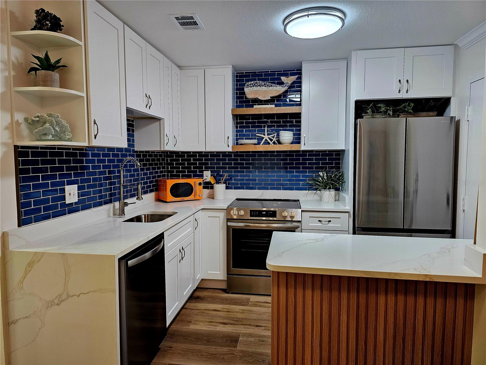 You will not find a cuter condo under $250k on the west coast of Florida! Model-like home featuring luxury vinyl plank flooring, quartz countertops with waterfall, coastal backsplash, stainless steel appliances, built in coffee/wine bar, custom cabinetry/trim, built in desk/office, updated bathrooms and fresh paint. Mediterranean Manors is a coastal retreat that has it all! Private beach, waterfront park with direct access to The Gulf, kayak launch, boat mooring, heated pool, clubhouse, tennis, pickleball, bocci, shuffleboard, fitness center, game room and library. The community has completed all Milestone Inspections, SIRS, and repair requirements. All assessments have been paid in full. NEW roof in 2025 and this unit comes with a covered carport and storage closet under carport. Building 2 is the ONLY building that allows rentals immediately with no waiting after closing. Across the street from Pinellas Bike Trail, and only a few short blocks to Dunedin Causeway, Dunedin Golf Club, marinas, Publix and restaurants! 2nd Floor unit with elevator so no worrying of flooding.