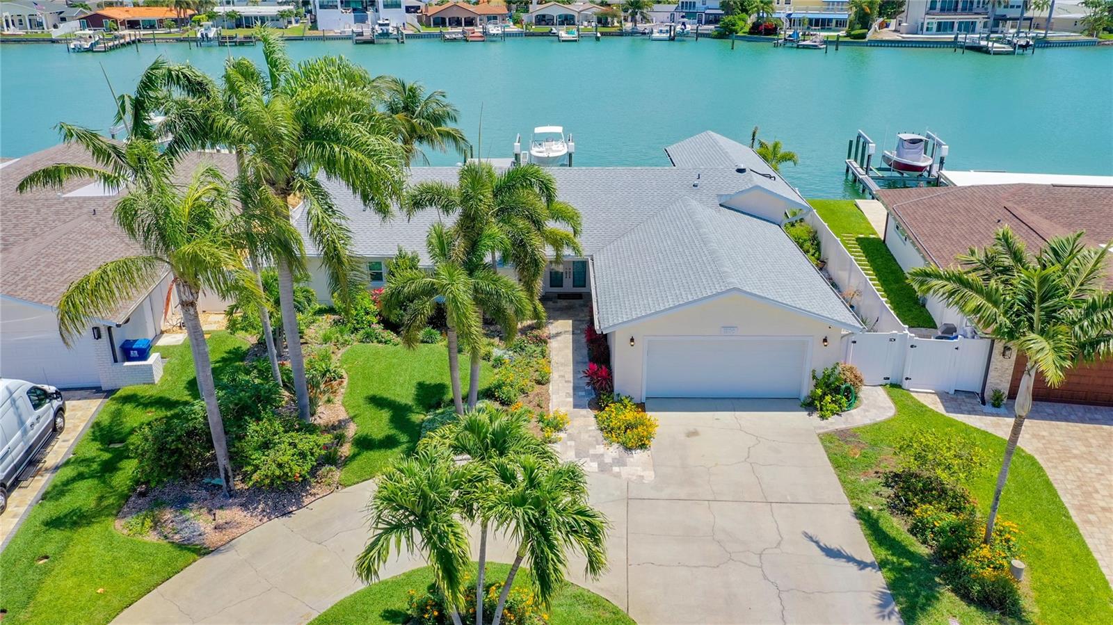 Under contract-accepting backup offers. The moment you cross the front threshold, you will feel it in your heart. You are home! Sparkling waters of the intracoastal waterway greet you, glistening just beyond the back wall of the home, a wall almost entirely of glass. If you have been hoping to find a brand new, fully modernized home, your heart's desires have been fulfilled! This house was lovingly rebuilt and modernized from the bottom up. All that remains from the original house is the concrete block on the exterior walls. Breathe in the light openness of the Great Room under its expansive cathedral ceilings, as music from the Klipsch 5.1 surround sound system fills the air - not only in this room, but in the master bed/bath and outdoors as well. Designed for the owner who loves to entertain. In the Great Room you will find a wine bar, a beverage cooler and a 46 bottle wine cooler. The Chef's Kitchen offers custom built cabinetry with rollout drawers and soft close doors. Every square inch of space has been carefully planned, making the convenience of electrical outlets and the amount of storage exceptional. Even the kick plates are pull-out drawers! Extremely unique, hidden walk-in pantry - You just have to see in person! All Wolf 30"oven, convection/steam oven and 36" gas cooktop with convenient above-cooktop pot filler, and a silent Bosch dishwasher. Beautiful high-end natural quartzite throughout the kitchen/center island.This is a 4 bed, 3.5 bath home. Both waterfront bedrooms could be considered dual masters. The first, now being used as a Guest Suite, has vaulted ceilings, an exterior entrance, custom cabinetry, and a dry bar with a built-in refrigerator. The large, ensuite guest bath has a granite vanity top with vessel sink and lighted vanity mirror. Once having experienced the roomy shower with massage shower head, three body sprays plus a rain head, your guest may never want to leave! Enjoy a beautiful open waterfront view beyond the 12 foot glass wall/ sliders of the Master Bedroom, just steps away from the hot tub/pool. His-and-Her large custom closets with built-in, stow-away ironing board. Master Bath epitomizes luxury. Custom cabinets and granite countertops with separate vanities and wall-mounted lighted mirrors. The large dual shower has a corner seat, 2 electronic shower valves with his and her sides. Her side has adjustable volume shower head, 12 inch rain head and a handheld. His side has massage shower head, rain head and three body jets. Bedroom 3/4 also have custom closets and ensuite custom bath. All bathrooms have comfort height water closets. The home's water is heated by tankless recirculating hot water heater.Travertine at the home's front entrance wraps around the side of house, coordinating with the pool decking. Step through a rain shower curtain cascading from the lanai roof into the pool and dive in for a cool dip in your natural gas, salt water pool/spa. Stretch out under an umbrella on the sun shelf as you run your fingers through the bubblers by your side. As evening falls, the beauty of glass bead pool finish and glass tile is brought out by colored LED lighting, easily controlled by Pentair Wi-Fi from your phone. Entertain in your outdoor kitchen with Kitchen Aid natural gas grill. Gather around custom, natural gas fire pit to share the day's stories. For a quiet moment, stroll down extra wide travertine steps to the composite dock, illuminated by accent lighting and new stringers to watch the dolphins playing. You are home!