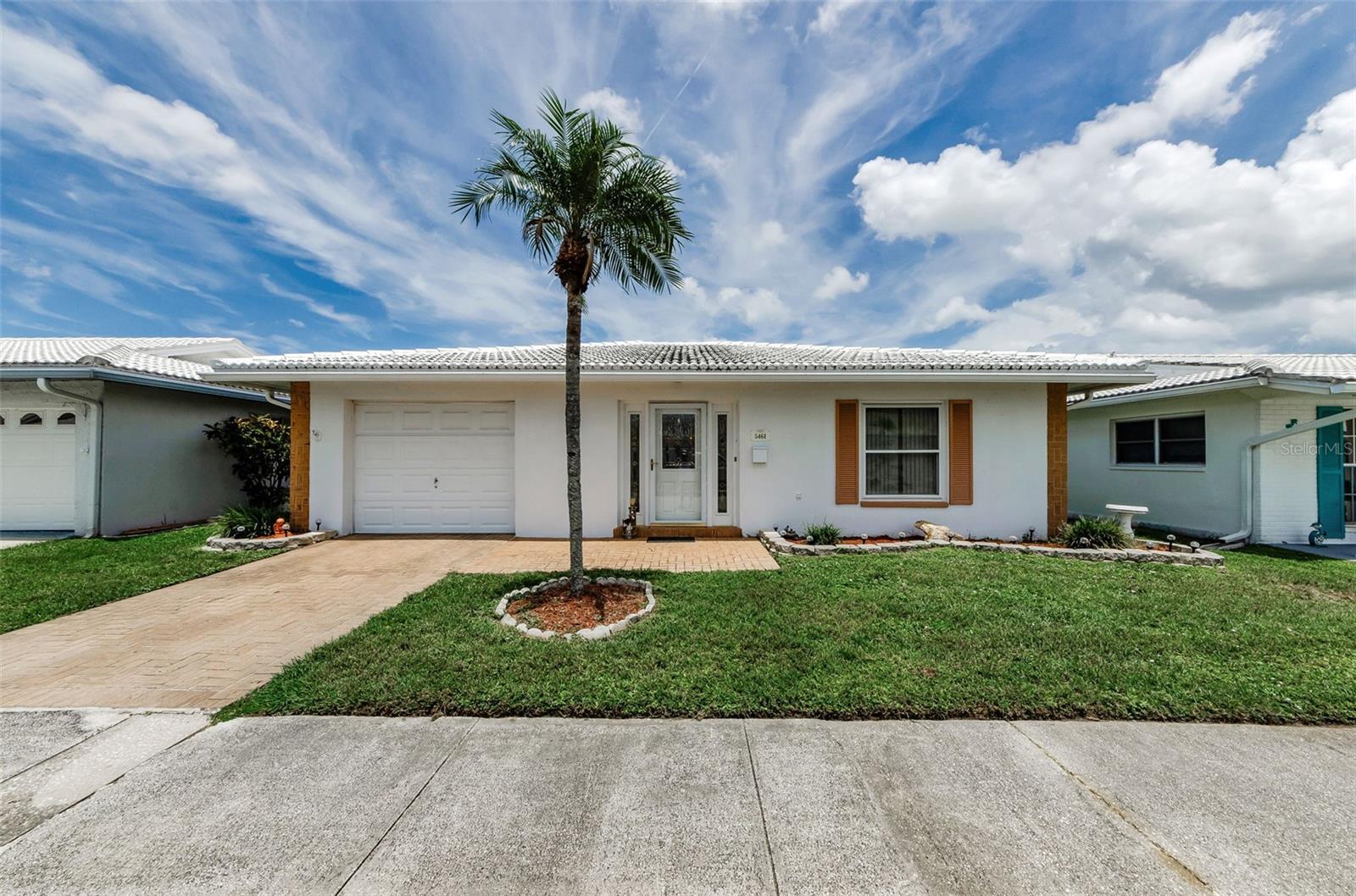 Welcome to Florida retirement living at its best in this spacious free-standing villa with a garage, in the desirable and active 55+ community of Springwood Villas 2. This Magnolia model with "1440" square feet offers a comfortable and functional floor plan. As you step through the leaded glass front door, you are greeted by a tiled foyer flanked by closets on each side. The foyer opens to the living/dining room combo. There is a large kitchen to the left of the dining room with a closet, pantry, and plenty of cabinets and countertops for food prep and storage. The kitchen dinette area is light and bright with chair rail accents. The family room features a large bay window and opens up to the kitchen and also leads into the primary suite with double closets and a private bathroom with a large wood vanity and shower. The guest bathroom is off the living room and has been remodeled with a tiled shower, glass doors, a raised toilet, a pedestal sink and tiled flooring. There is also a linen closet in the hallway next to the second good-sized bedroom with a large closet. Just off the kitchen is the oversized garage with the washer and dryer, along with built-in storage and attic access. This home also features newer double-pane windows, a brick paver driveway and front patio, a new A/C unit in 2024, Flat roof replaced in 2023, Electrical panel in 2020., rain gutters and an insulated glass front storm door. Springwood II is a pet-friendly, well-managed community with no current assessments. The clubhouse is just a short walk away, offering residents resort-style amenities, including a heated pool and a screened lanai overlooking the lake and gazebo, sauna, shuffleboard courts, fitness center, game room with billiards, ping-pong, card tables, a library and a banquet kitchen. There is a monthly community newsletter with a Calendar of events for residents to enjoy, including exercise classes, water aerobics, seasonal parties, events, and bingo! Residents can also rent out the large or small banquet hall for private gatherings. In addition to the amenities, the low monthly fee of $589. includes lawn care, water, sewer, garbage, and recycling, pick-up, property insurance, high-speed Internet, and over 200 cable channels. Springwood 2 is ideally located within minutes to grocery stores, shopping, restaurants, entertainment, health care professionals and everything else you may want or need! Less than 30 minutes to the sparkling Gulf beaches and a quick trip to the airport or any of the Tri-county attractions.