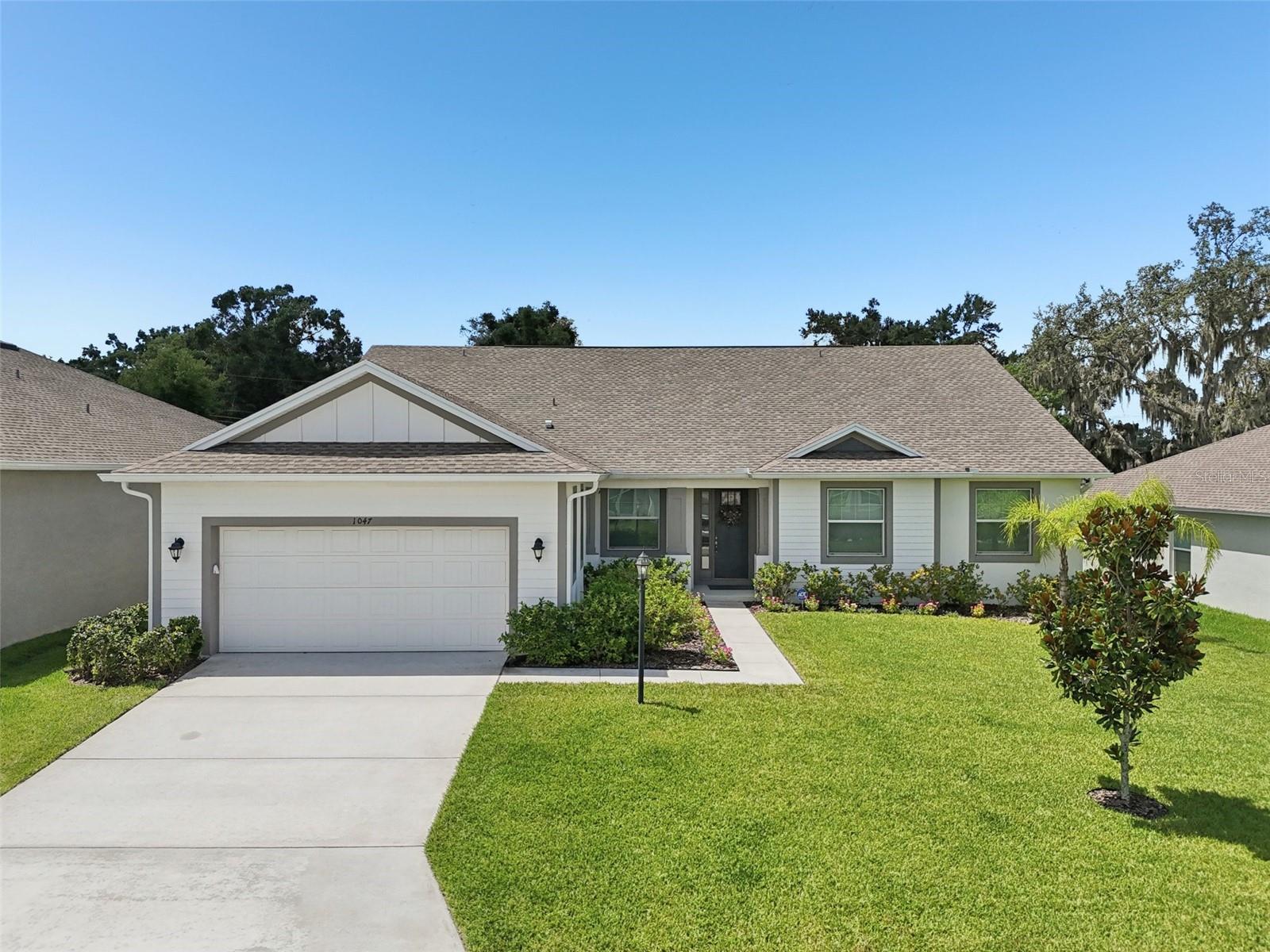 Welcome to 1047 Woodland Oaks Drive, located in the gated and highly sought-after South Lakeland community of Woodland Oaks. Built in 2022, this former Southern Homes “Manchester” model offers an ideal blend of space, functionality, and elevated finishes throughout—all just steps from community amenities including a pool, playground, dog park, pickleball and basketball courts.
With 4 bedrooms, 3 bathrooms, and a flexible triple-split layout, this home spans 2,612 square feet of thoughtfully designed living space. From the moment you enter, you’ll notice 8-foot doors, luxury vinyl plank flooring, and an open-concept flow perfect for both daily living and entertaining. The kitchen is a true standout with bright 42” shaker cabinetry accented by crown molding, granite countertops, stainless steel appliances (including a brand-new refrigerator), walk-in pantry, and a large center island with bar seating.
A versatile bonus room near the entry makes the perfect formal dining space, office, or playroom. The private primary suite features tray ceilings, dual walk-in closets, a stand-alone soaking tub, oversized walk-in shower, separate water closet, and dual sinks with granite countertops.
Two secondary bedrooms share a full bath with a tub-shower combo and single vanity, while the fourth bedroom sits adjacent to a third bath with a walk-in shower—ideal for guests or multigenerational living. The interior laundry room is conveniently tucked away and includes cabinetry for storage (washer and dryer do not convey).
Step outside to enjoy the 288-square-foot screened lanai with water-resistant parquet-style flooring and ceiling fans, all overlooking a large backyard, with ample space to create your very own oasis.
Additional features include a smart home thermostat, rain gutters, double-pane windows, and WiFi-enabled appliances. Located within a gated community with impressive amenities and zoned for highly-rated nearby schools, this home offers the space and convenience today’s households are looking for—all in a beautiful, well-maintained neighborhood. Schedule your private showing today!