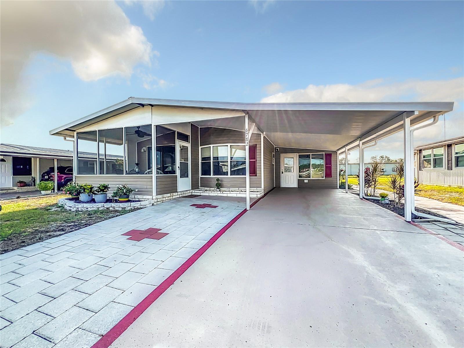 Welcome to 6782 Brentwood Dr. NE in Lake n Golf Estates—a desirable 55+ lakefront community on the north side of Winter Haven where you OWN the land. This beautifully maintained 2-bedroom, 2-bathroom manufactured home offers a comfortable and move-in ready lifestyle with numerous recent updates. As you enter through the enclosed Florida room, you’ll immediately notice the fresh paint and new carpeting, creating a welcoming first impression. This space is fully integrated into the central air and heat system and also features a wall-mounted AC unit for added comfort. Just beyond, a spacious workshop with double doors provides ample room for storage or golf cart parking.
Inside, updated vinyl plank flooring flows throughout the home. The split-bedroom layout offers privacy and functionality, with two generously sized bedrooms, each with walk-in closets. The primary suite includes an ensuite bathroom, while guests will enjoy a refreshed hall bathroom. On the opposite side, the kitchen boasts beautiful stainless steel appliances, a stylish backsplash, and plenty of counter space. The adjoining dining area features built-in cabinetry for extra storage and connects seamlessly to the open living room. Sliding glass doors lead from the living area to the front lanai, where you can enjoy partial lake views and the relaxing Florida breeze.
This home has been thoughtfully updated over the years, with a metal roof (approximately 9 years old), central AC unit (approximately 6 years old), water heater (approximately 4 years old), and updated stainless steel appliances. Most recently, in the spring of 2024, the home received brand-new siding, updated flooring, updated ceiling fans, refreshed landscaping, and updated screens in the Florida room.
Lake n Golf Estates offers an active lifestyle with amenities including a boat dock and ramp, clubhouse, pool, spa, and shuffleboard courts. The low annual HOA fee of just $550 makes it an affordable option for year-round or seasonal living. Conveniently located near HWY 27, this home offers easy access to shopping, dining, medical facilities, and Winter Haven’s chain of lakes. Plus, it’s just about an hour from Disney and roughly 90 minutes to either coast.
Don’t miss this opportunity to enjoy Florida living at its best—schedule your private showing today!
