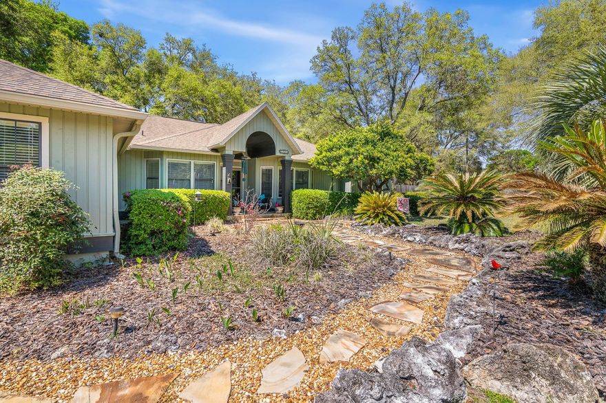 Beautifully maintained home situated on a full acre in a park like setting, tucked away on a quiet dead-end street with no HOA! This is no cookie-cutter property - its charm is evident from the moment you step onto the inviting flagstone walkway and take in the exceptional curb appeal. The kitchen features stone countertops and updated appliances including gas stove, perfect for both everyday living and entertaining. This spacious home offers 4 bedrooms plus a study, which includes a versatile mother-in-law suite or second family room complete with a half bath. Warm earth tones flow throughout the home, creating a cozy and welcoming atmosphere. The living room is especially inviting, centered around a fireplace and offering serene views of the backyard. The primary suite has been tastefully updated with a glass sliding door to the outdoor deck and a barn door that opens into the bathroom for a relaxing soaking tub. Step outside to enjoy a large deck overlooking a private, fenced backyard with a tranquil fish pond—perfect for unwinding or hosting gatherings. There’s also plenty of space for gardening, and even chickens are welcome! Additional highlights include energy-efficient R-30 insulation, low electric bills through Clay Electric, and newer well and septic systems installed in 2022. The property also features a 2-car garage and a separate workshop with electricity. Ideally located with convenient access to I-75, this home offers the perfect blend of privacy, functionality, and accessibility. Zones for all A rated schools, Meadowbrook, Fort Clarke Middle & Buchholz High School.