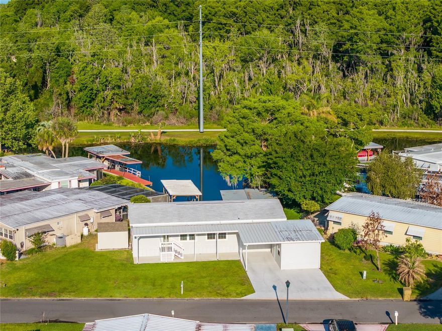 Welcome to your waterfront oasis! Built in 2021, this 3 bedroom/2 bathroom modular home is situated on a canal with direct access to the Harris Chain of Lakes, offering the perfect blend of contemporary comfort and the serene Florida lifestyle! Step inside to an open-concept floor plan highlighted by crown molding and luxury vinyl flooring throughout for a sleek, low-maintenance finish. The heart of the home is the chef-inspired kitchen, boasting Whirlpool stainless steel appliances, an oversized island, and a farmhouse sink perfectly positioned to overlook the water. The spacious primary suite offers a large walk-in closet and a private ensuite bath with a double vanity and a modern walk-in shower and linen closet. Just steps from the primary suite, find a convenient INDOOR laundry room. Whether you need a dedicated home office, hobby room, or cozy guest space, the two additional bedrooms provide total flexibility. Life on the water is made easy with a newly reinforced dock, and the dock walkway has been newly updated.  Canal-side irrigation well offers significant savings on water usage.  This property also features a a PEST GUARD SYSTEM in-place around the outside perimeter.  The large lot and expansive outdoor living areas-including a covered porch and an open patio-capture stunning panoramic views, while the private boathouse ensures your boat is always ready for a day on the Harris Chain of Lakes. This property offers a double driveway with space for three vehicles, PLUS a golfcart!  You will love the TWO sheds for additional storage space/workshop area. HOA/COMMUNITY: Imperial Terrace West is a highly desirable 55+ retirement community offering AMENITIES galore! Community amenities include a clubhouse, boat slips, Harris Chain of Lakes access, shuffleboard courts, an indoor pool and hot tub, and so much more! Featuring a low HOA fee and NO LOT RENT - you OWN the land! Imperial Terrace is located off Hwy 441, just minutes from shopping, dining, entertainment, state-of-the-art medical facilities, PLUS, renowned local destinations - Mount Dora and The Villages! Easily commute to the beach coasts, Orlando attractions, airports and everywhere exciting that makes Floridians love living ‘central’ in the Sunshine State, year ‘round or seasonal. Call to schedule your personal tour today!